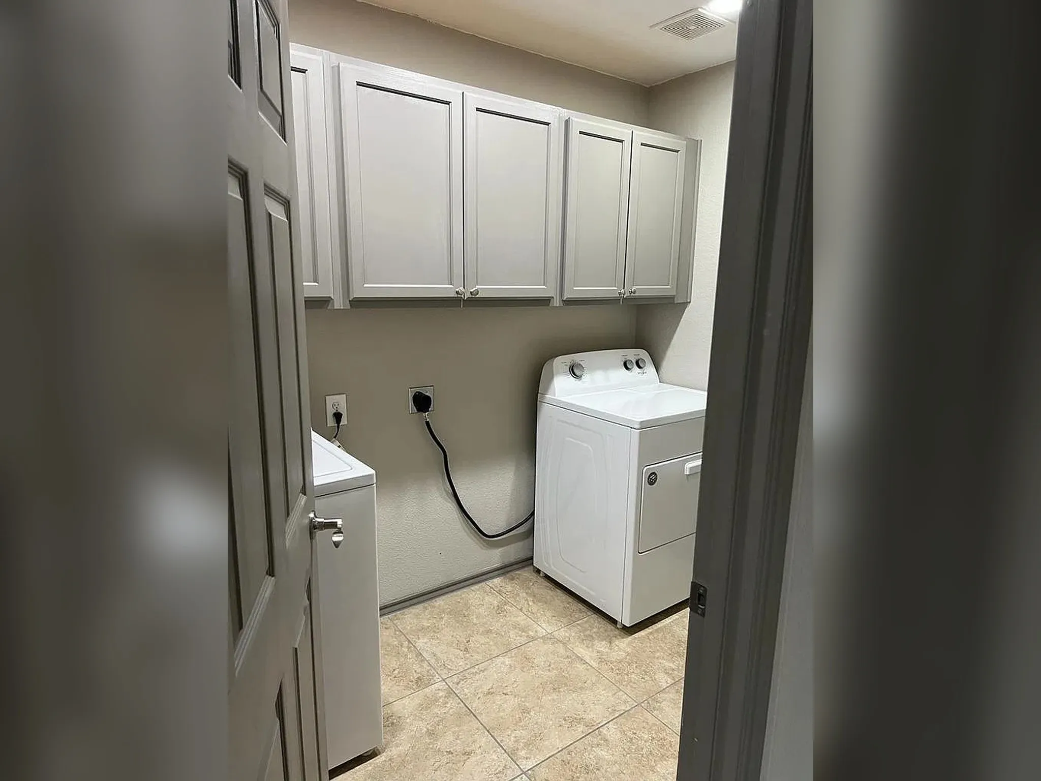 Laundry space featuring upper cabinetry, tile flooring, and integrated wall outlets