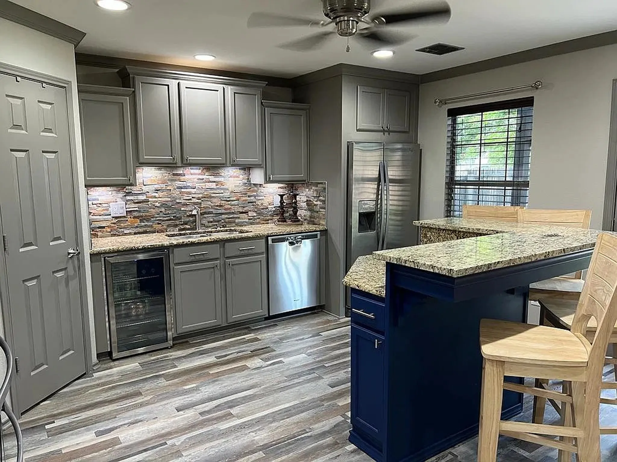 Kitchen featuring wood-finish flooring, undermount sink, built-in beverage refrigerator, recessed lighting, and a ceiling fan