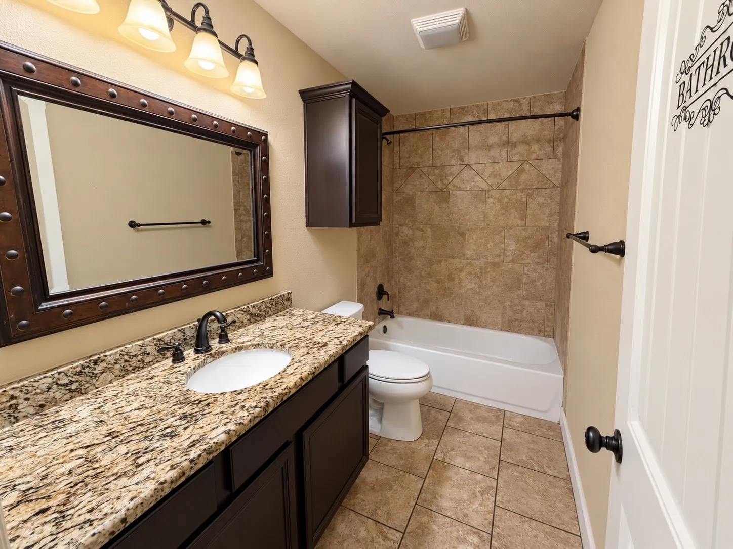 Vanity with a granite countertop, undermount sink, and oil-rubbed bronze fixtures