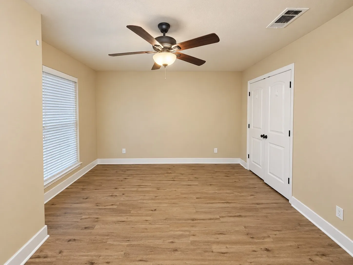 Wood-finish flooring with white trim and neutral wall tones