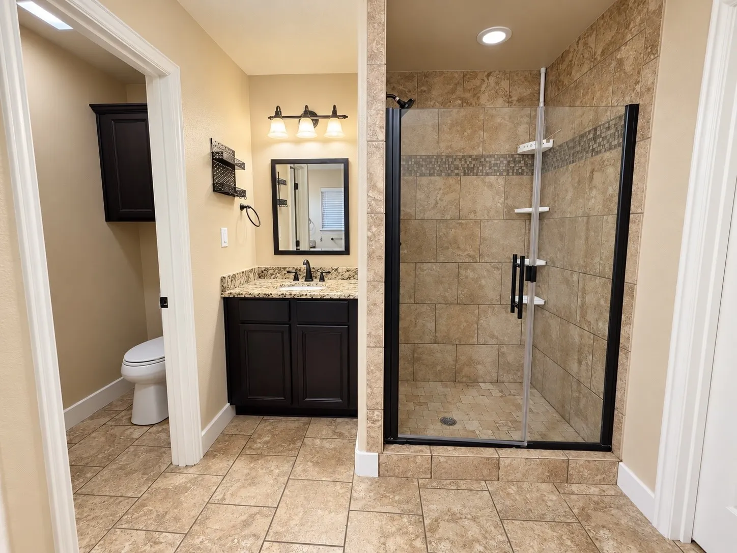 Tiled flooring complemented by a walk-in shower with glass enclosure and tiled surround