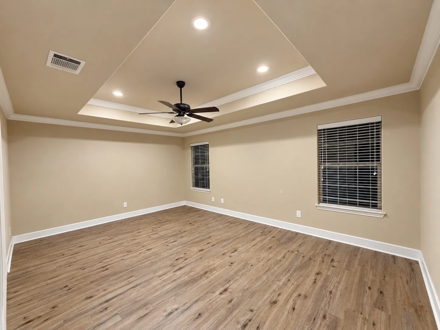 Tray ceiling with recessed lighting and a ceiling fan, wood-finish flooring, and two windows with​​‌​​​​‌​​‌‌​‌‌​​​‌‌​‌​‌​‌​​​‌​​ blinds