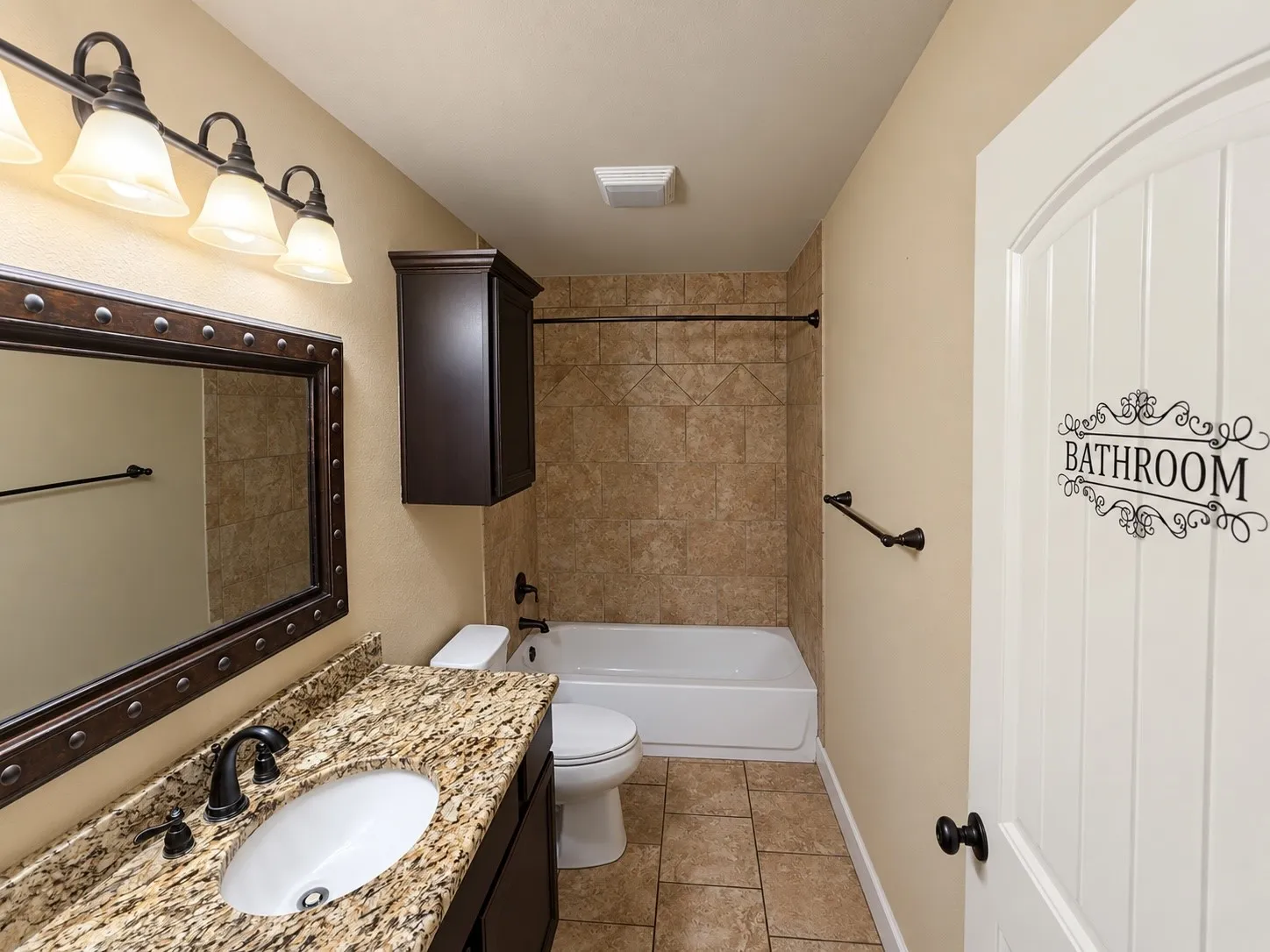 Vanity with a light-toned stone countertop, integrated oval sink, and dark bronze-finish faucet