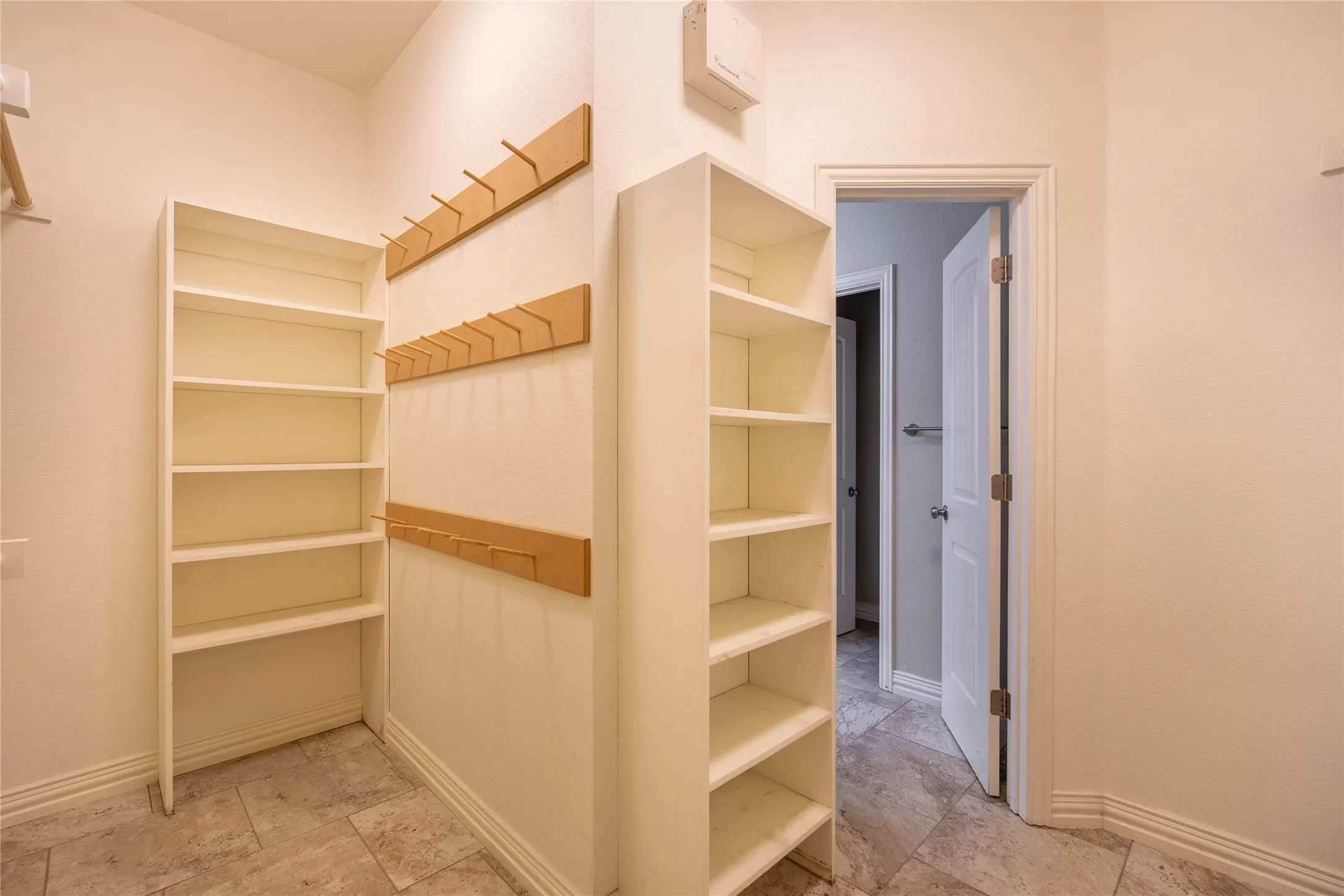 Built-in shelving, wall-mounted coat racks, and tiled flooring