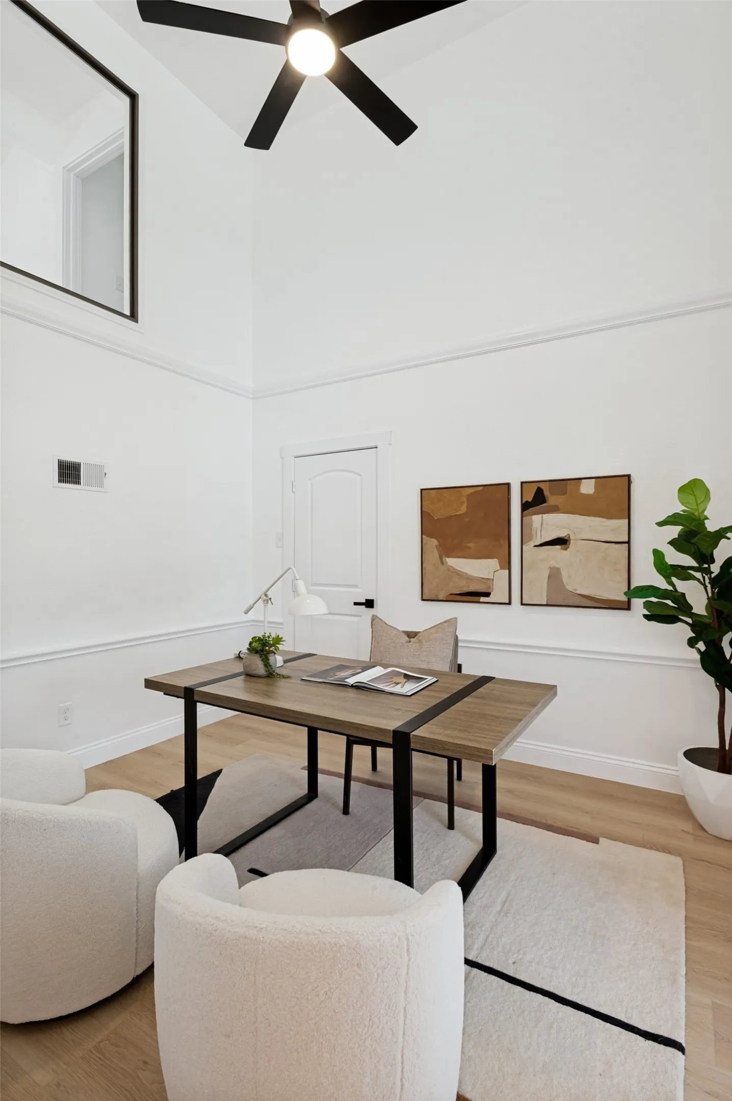 Vaulted ceiling, black ceiling fan, luxury vinyl plank flooring, white walls, and crown molding
