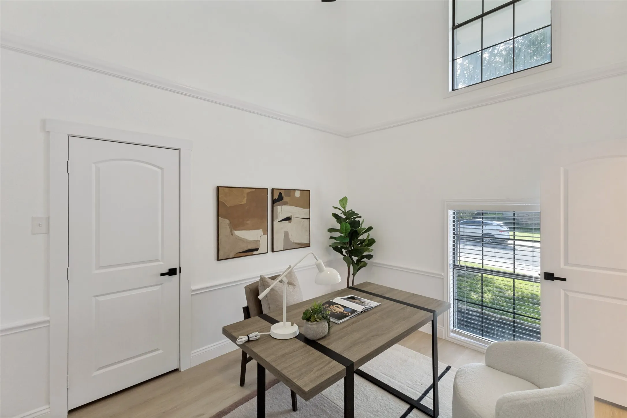 Vaulted ceiling with crown molding, wainscoting, luxury vinyl plank flooring, and a large window with blinds