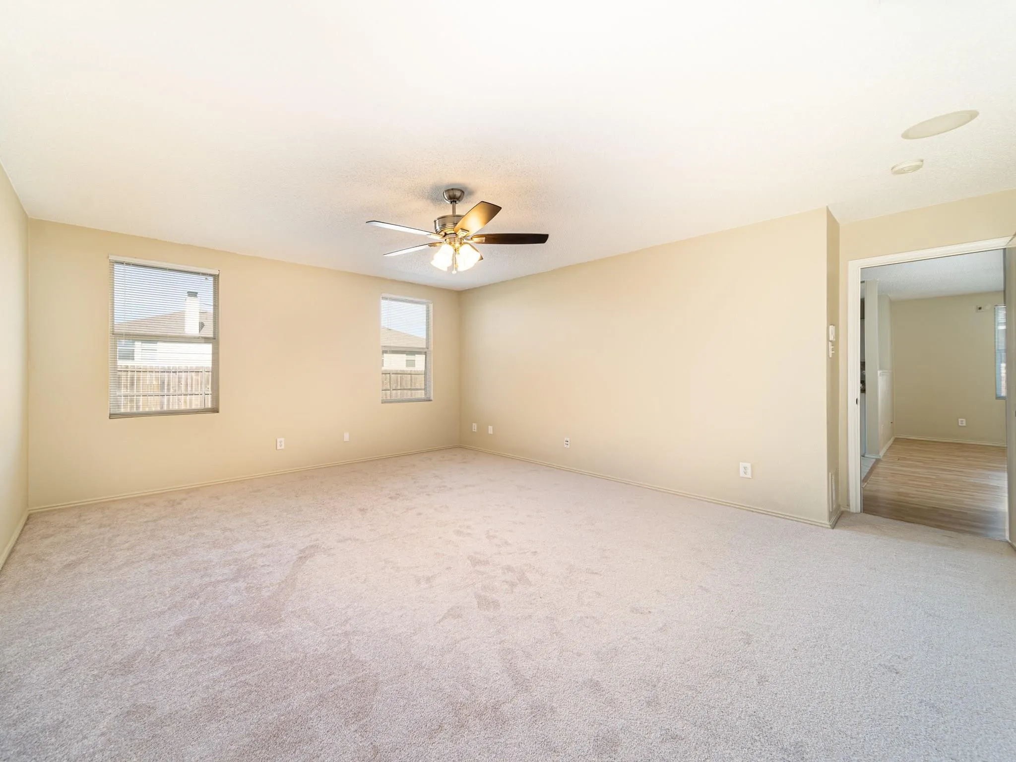 Carpeted flooring, ceiling fan with integrated lighting, recessed ceiling speakers, and dual windows