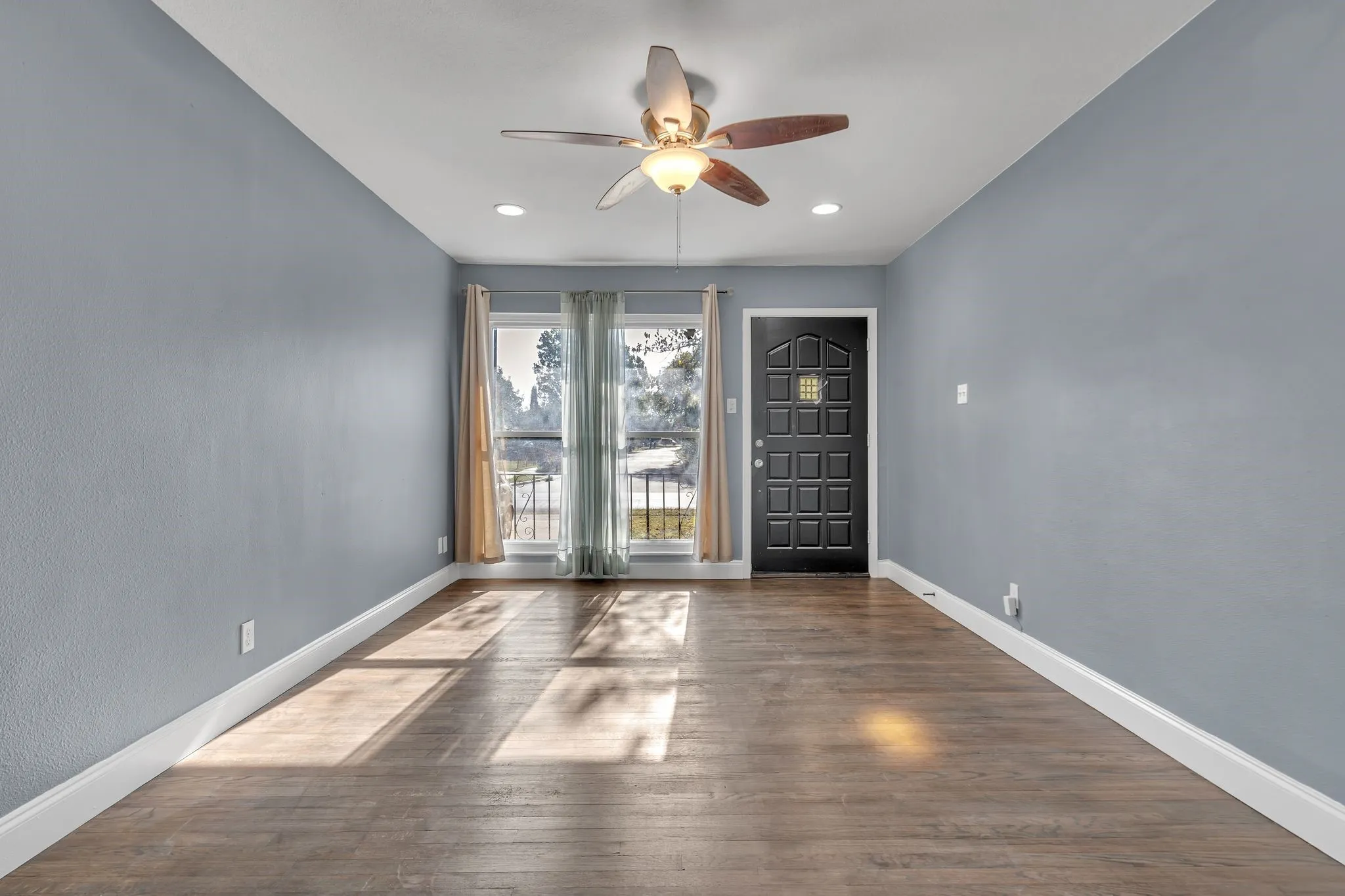 Wood-finish flooring throughout, complemented by a ceiling fan with integrated lighting
