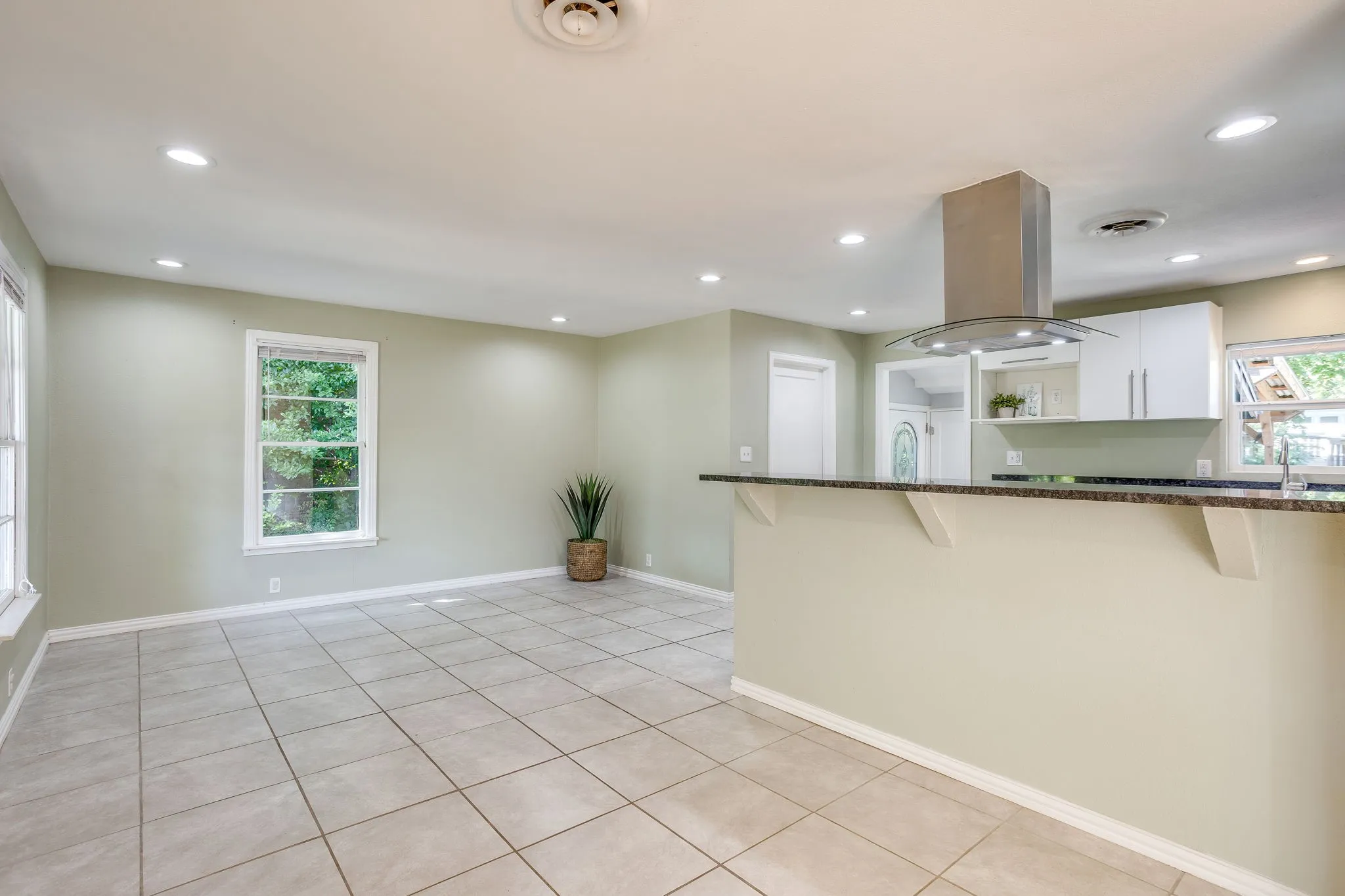 Open-concept space featuring ceramic tile flooring, recessed ceiling lighting, and multiple windows