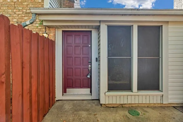 Entry featuring a multi-panel door with a metal kick plate, paired with double windows and horizontal siding