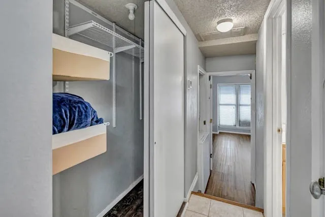 Closet featuring wire shelving and white sliding doors, with wood-finish flooring and neutral wall paint