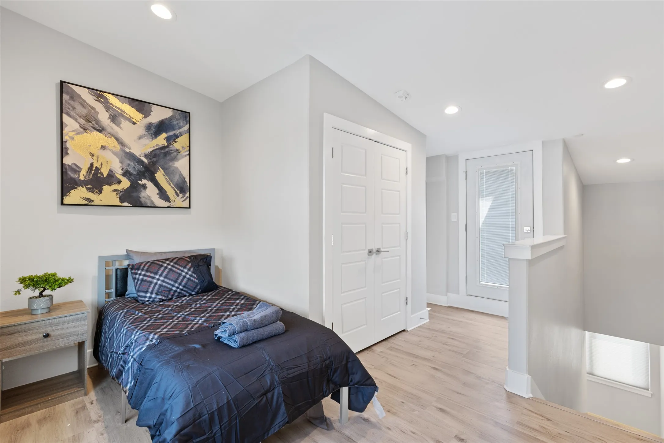 Recessed lighting, wood-finish flooring, paneled interior door, and a glass-paneled exterior door