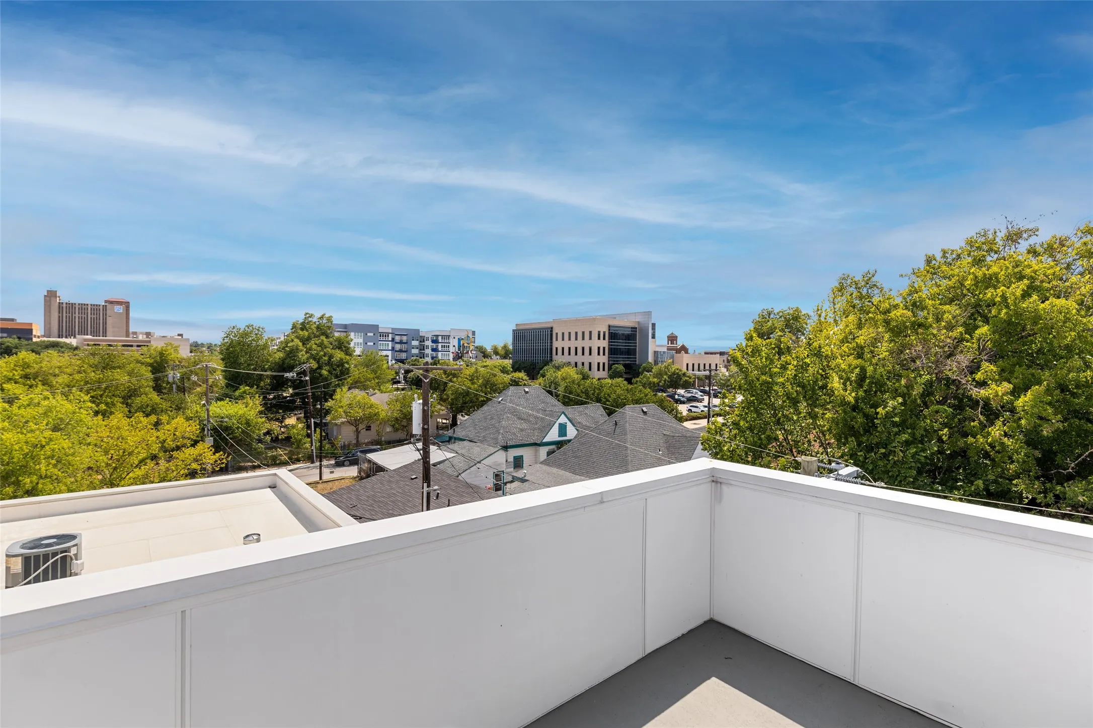 Rooftop deck featuring a grey flooring surface and white panel walls