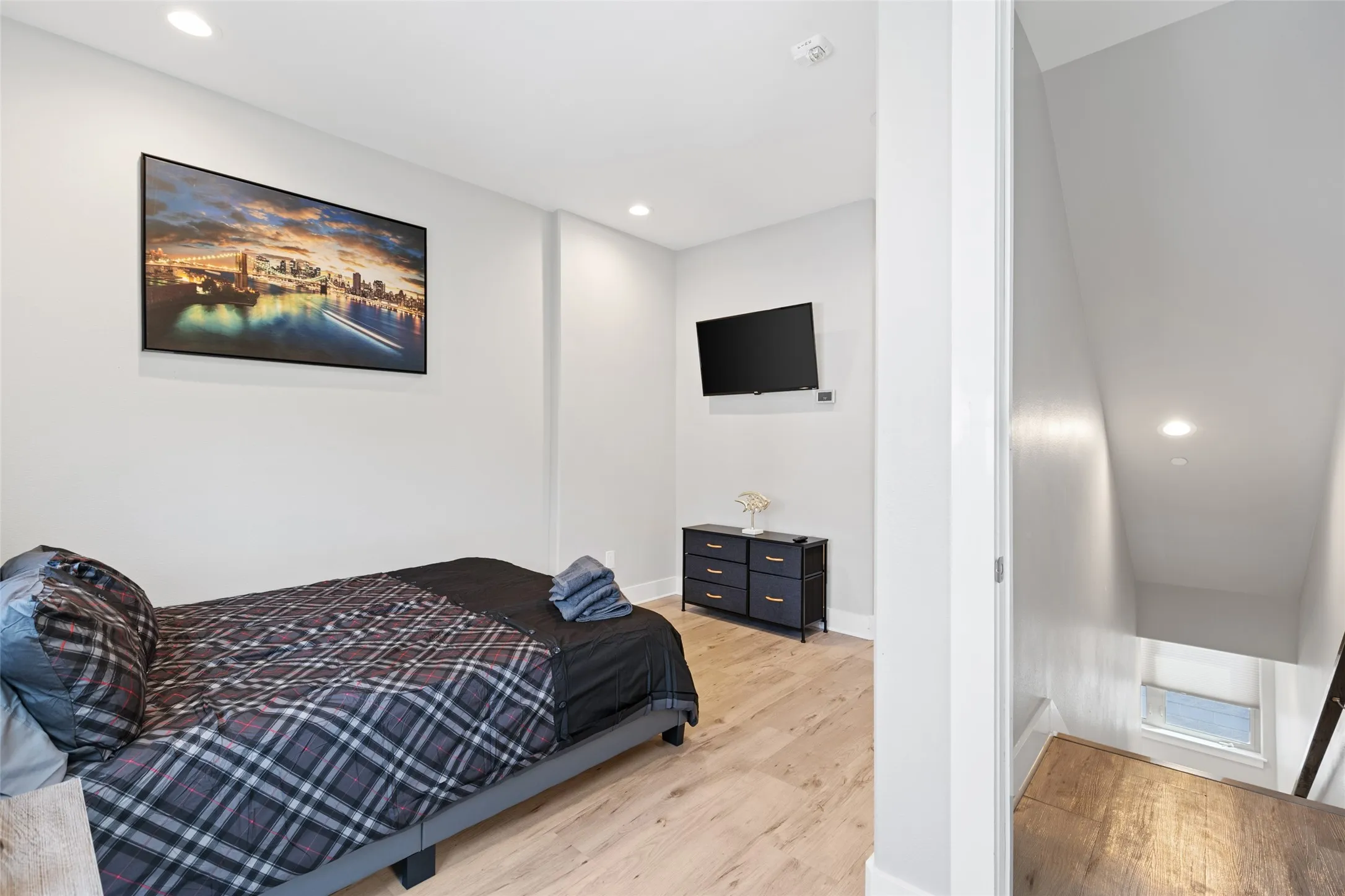 Recessed lighting, wood-finish flooring, and white walls