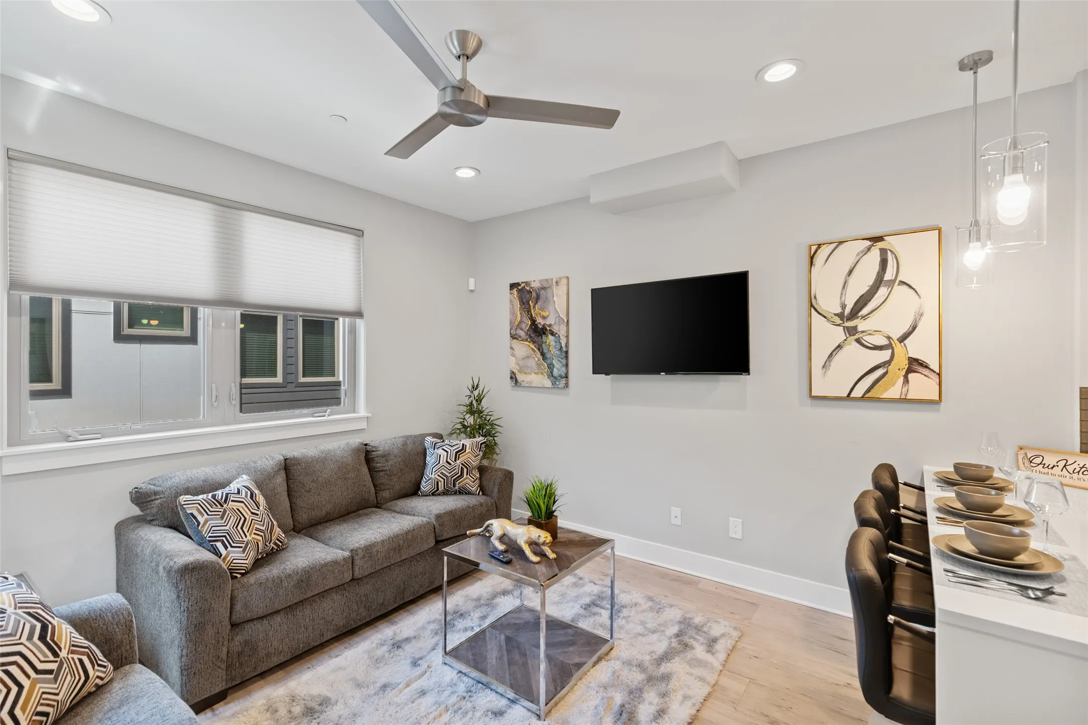 Recessed lighting, ceiling fan, and pendant lighting illuminate the space