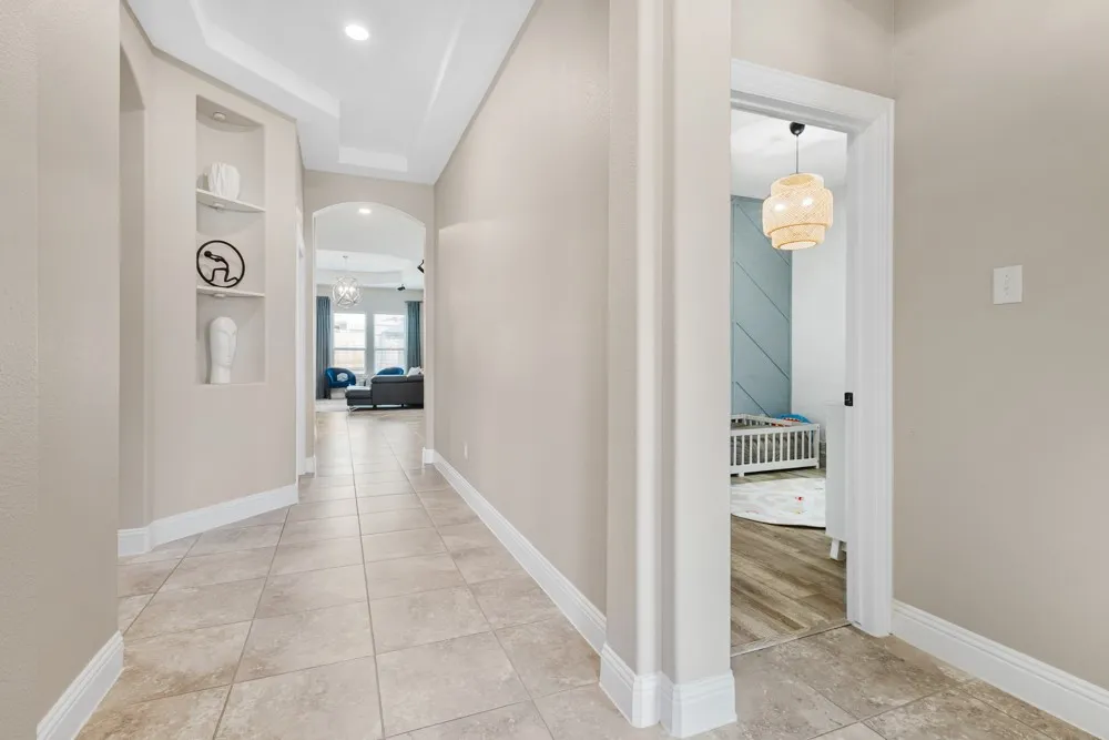 Tiled flooring, tray ceilings with recessed lighting, built-in wall niches, arched doorway focal points greet you upon entry into the home.  2 secondary bedrooms and a bath are located to the right.