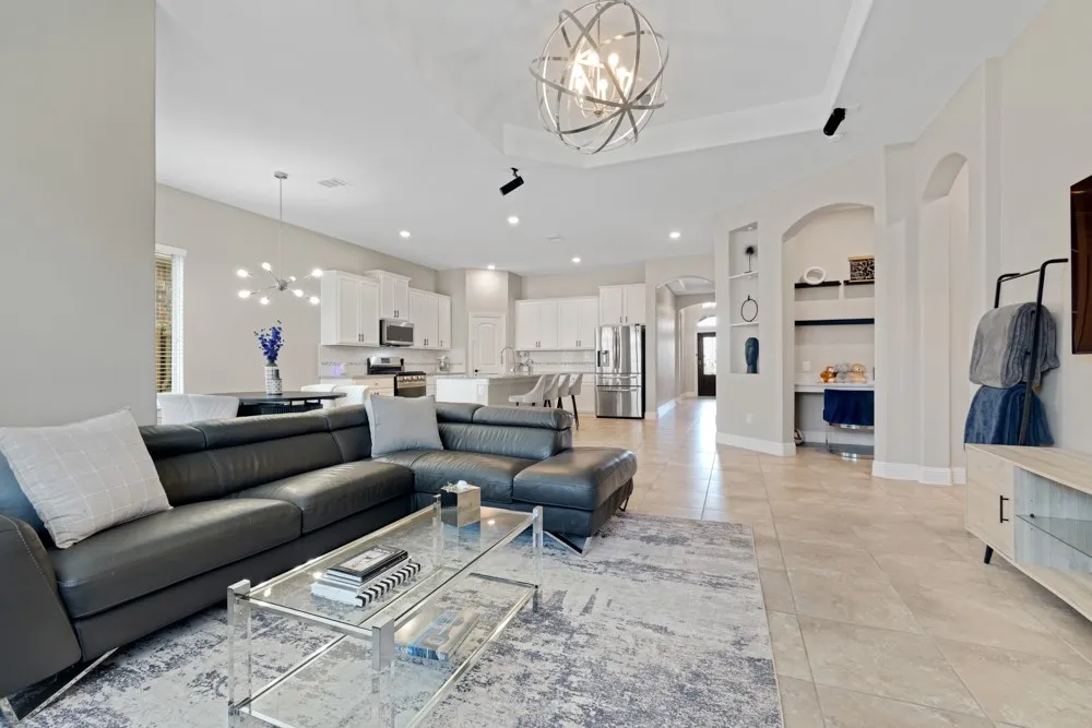 Embrace the modern stylings of this open floorplan with soaring ceilings, contemporary lighting fixtures, a tiled fireplace surround, and surround sound speaker system.
