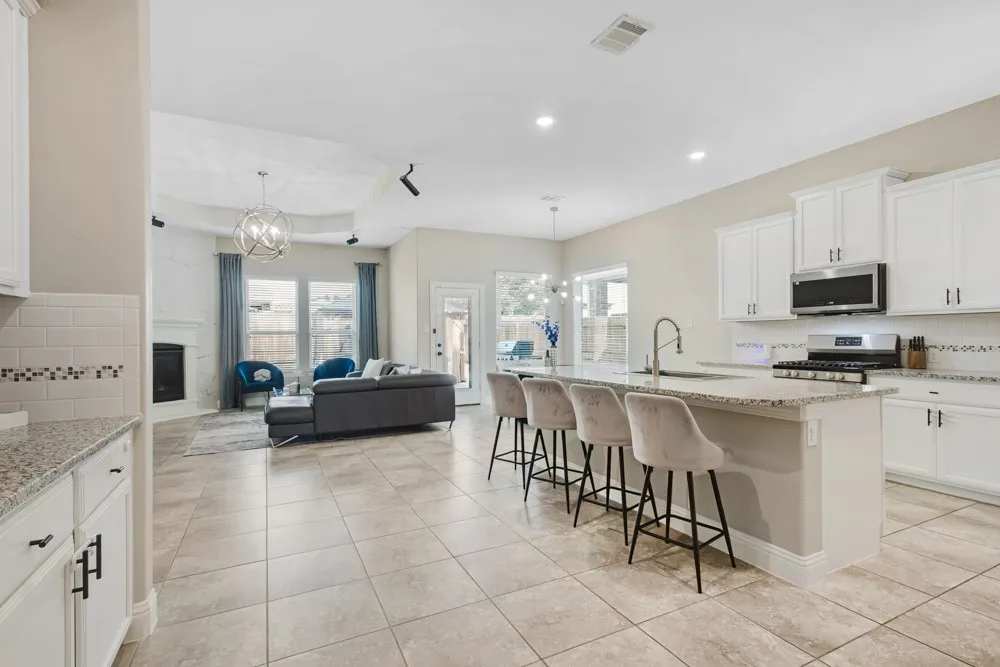 The tile in this stunning kitchen flows seamlessly into the dining area and living room​​‌​​​​‌​​‌‌​‌‌​​​‌‌​‌​‌​‌​​​‌​​ space.