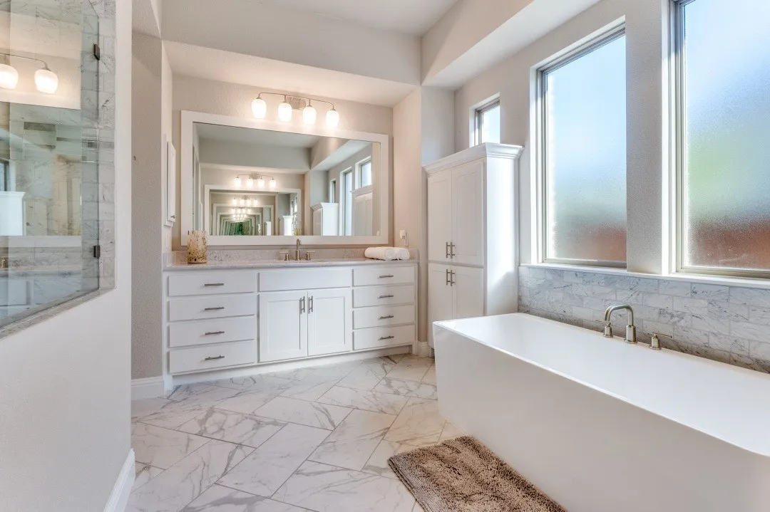 Primary bathroom has  separate vanities.
