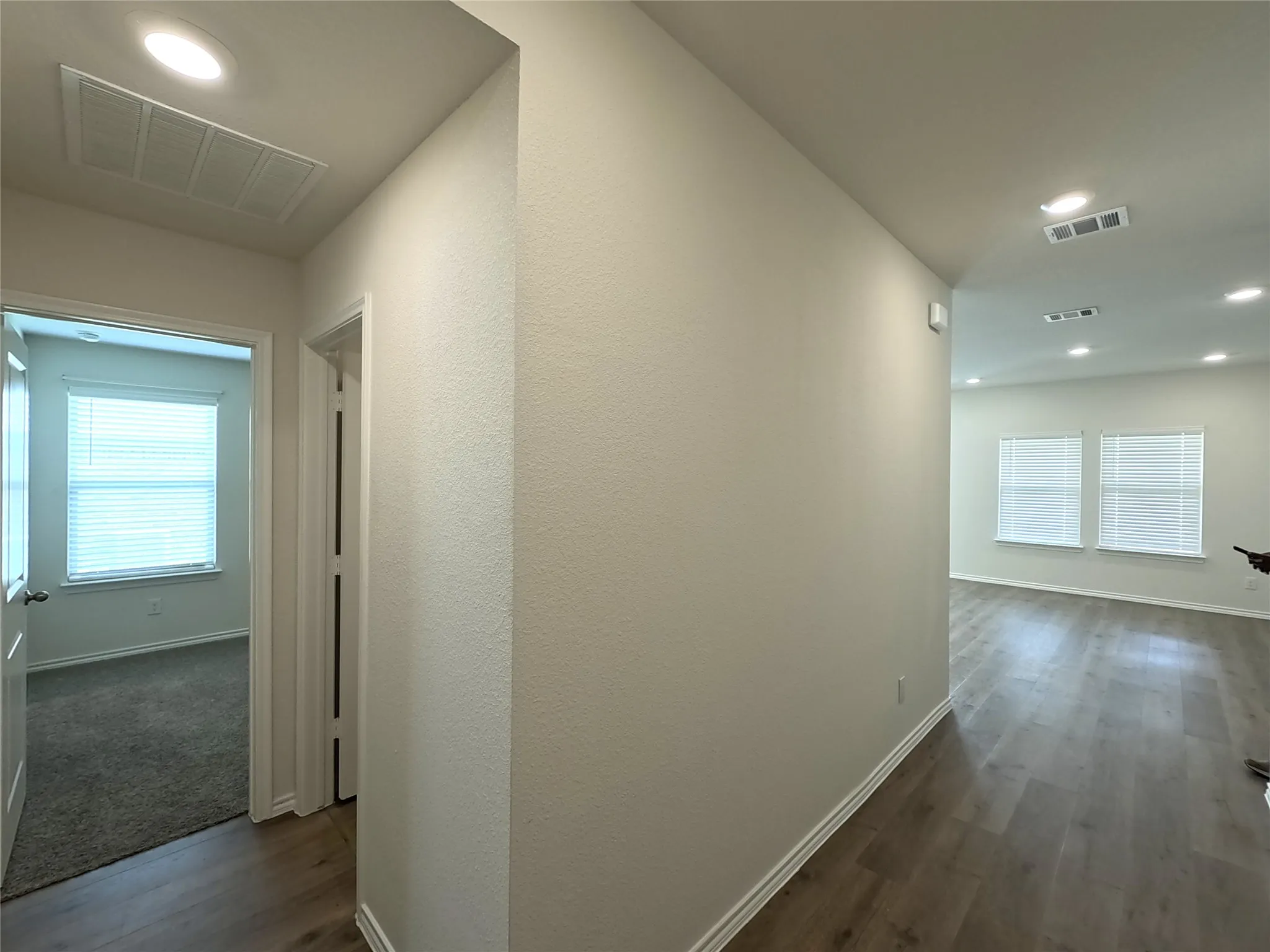 Recessed lighting illuminates the wood-finish flooring throughout the main living areas
