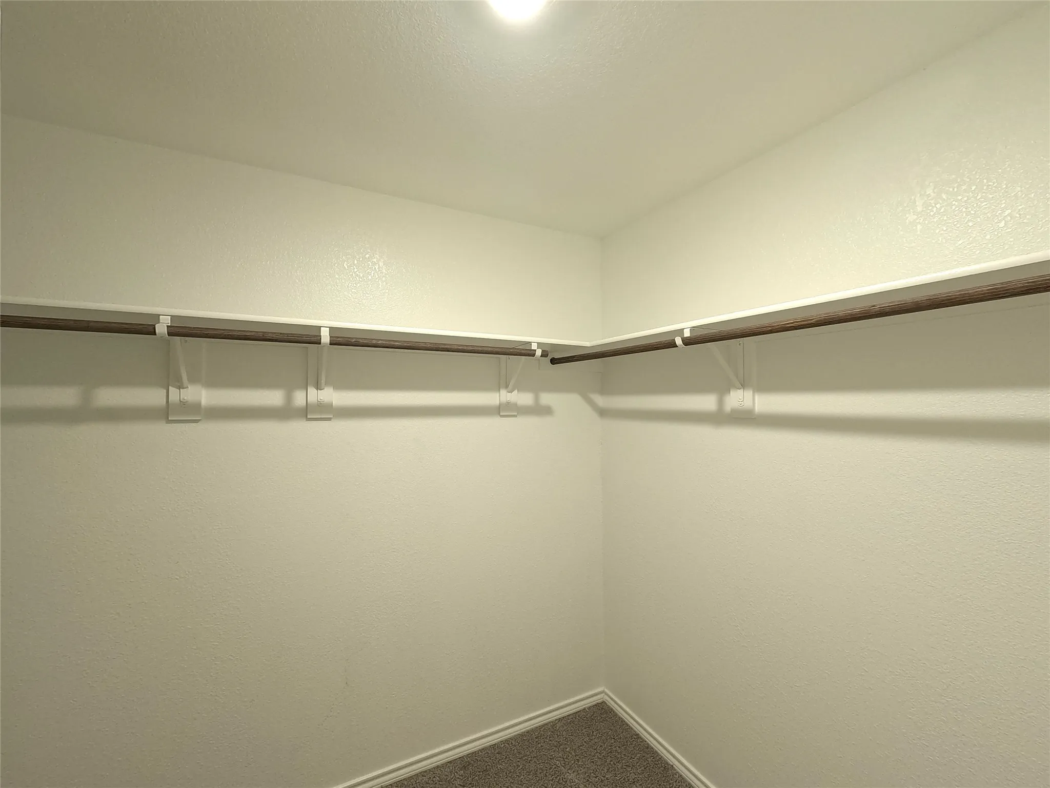 Corner closet with built-in shelving and hanging rods