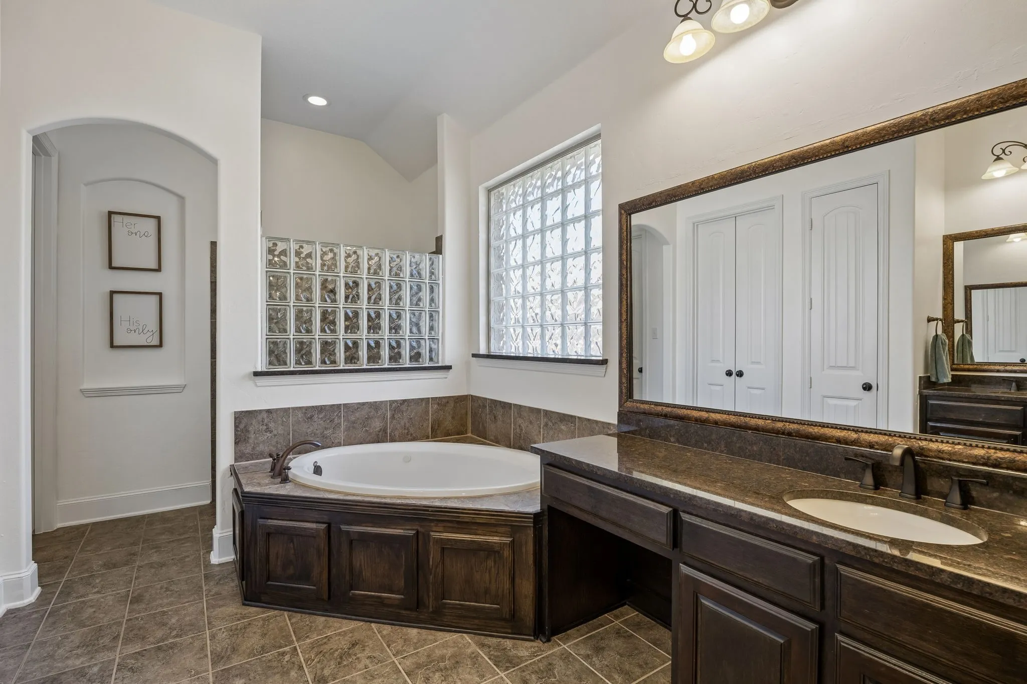 The ensuite primary bathroom features a soaking tub and separate vanities