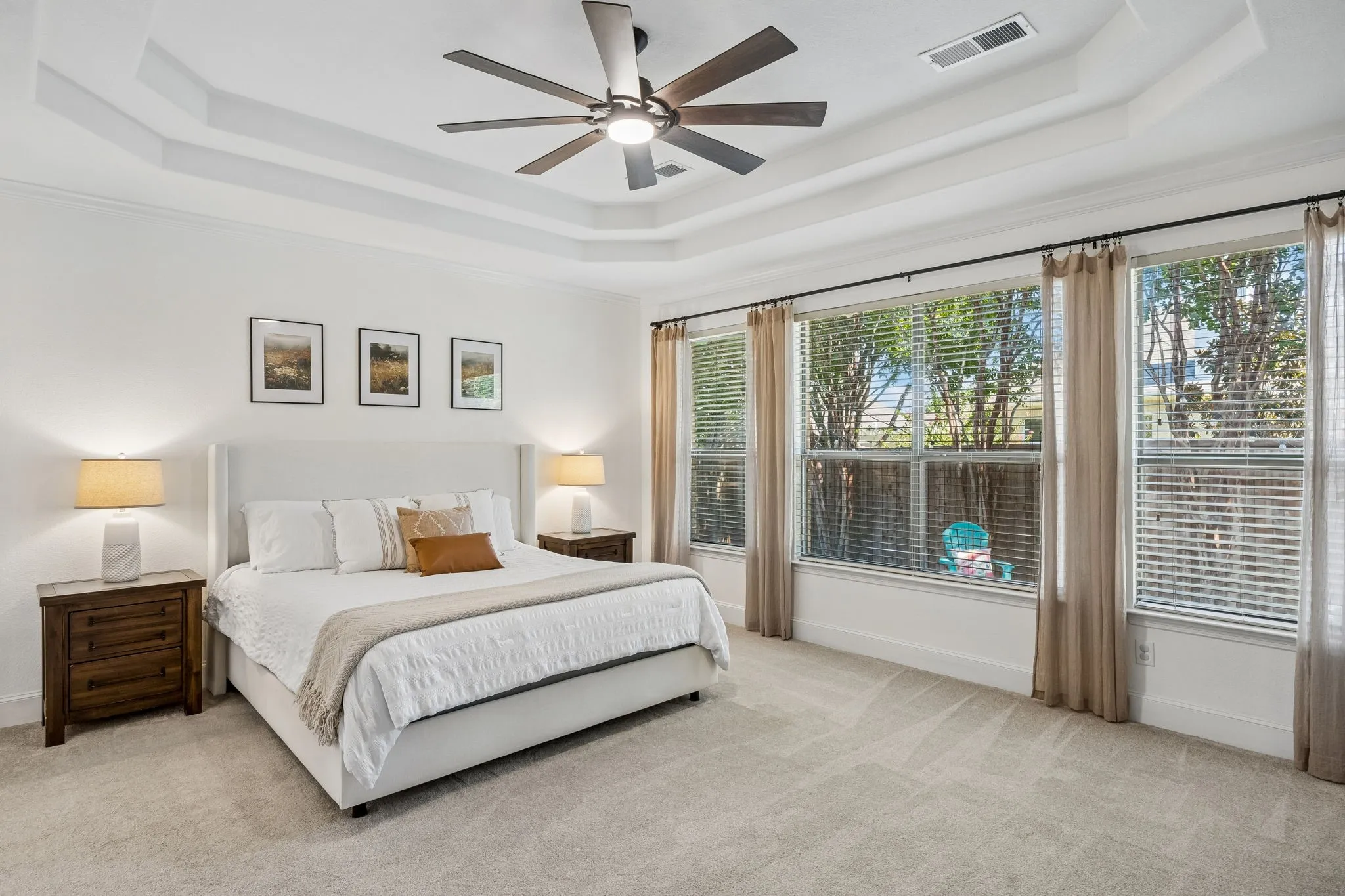 The primary suite features a double trayed ceiling and a wall of windows to the back yard.