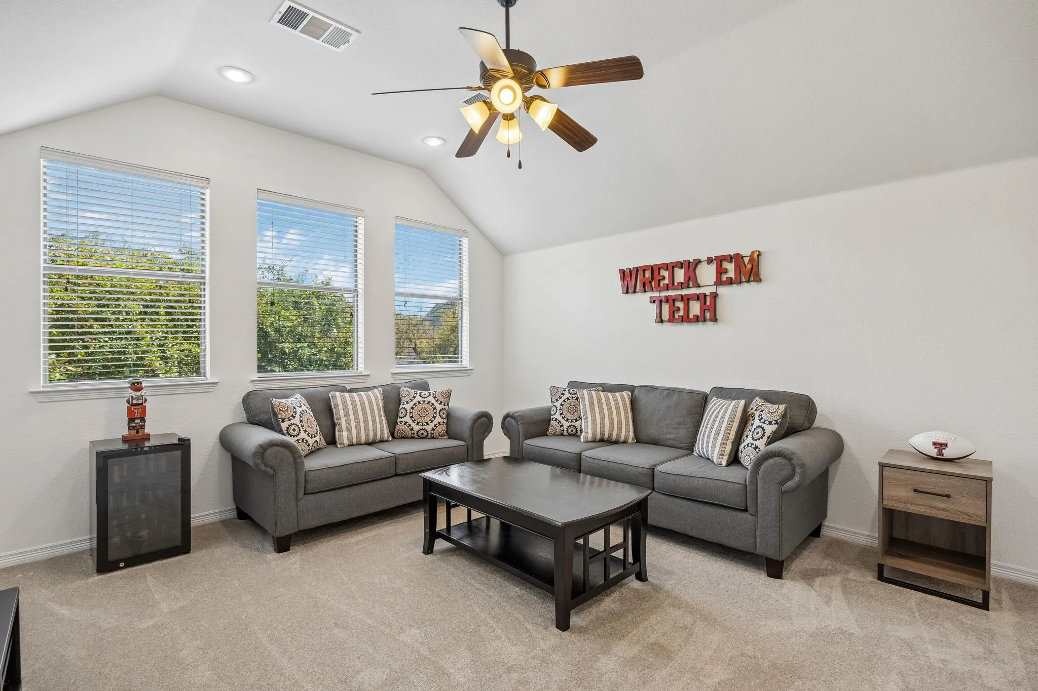 Upstairs game room with a vaulted ceiling with a fan. This flexible space could also be a bedroom or even a mother in law suite as it has an endure bath and closet.