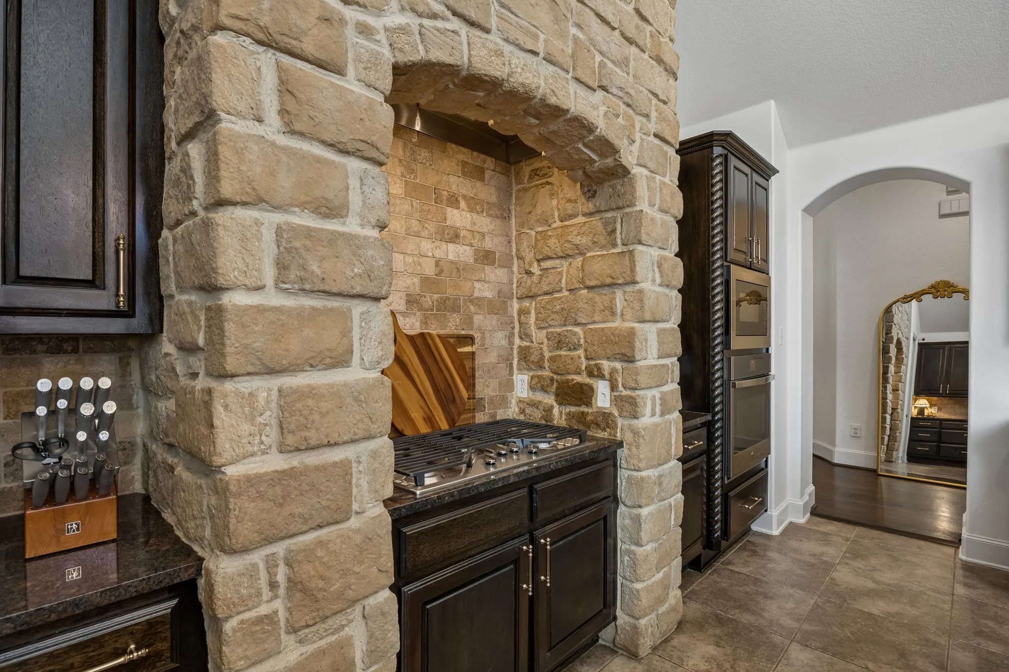 Stone-clad range hood surround with integrated gas cooktop