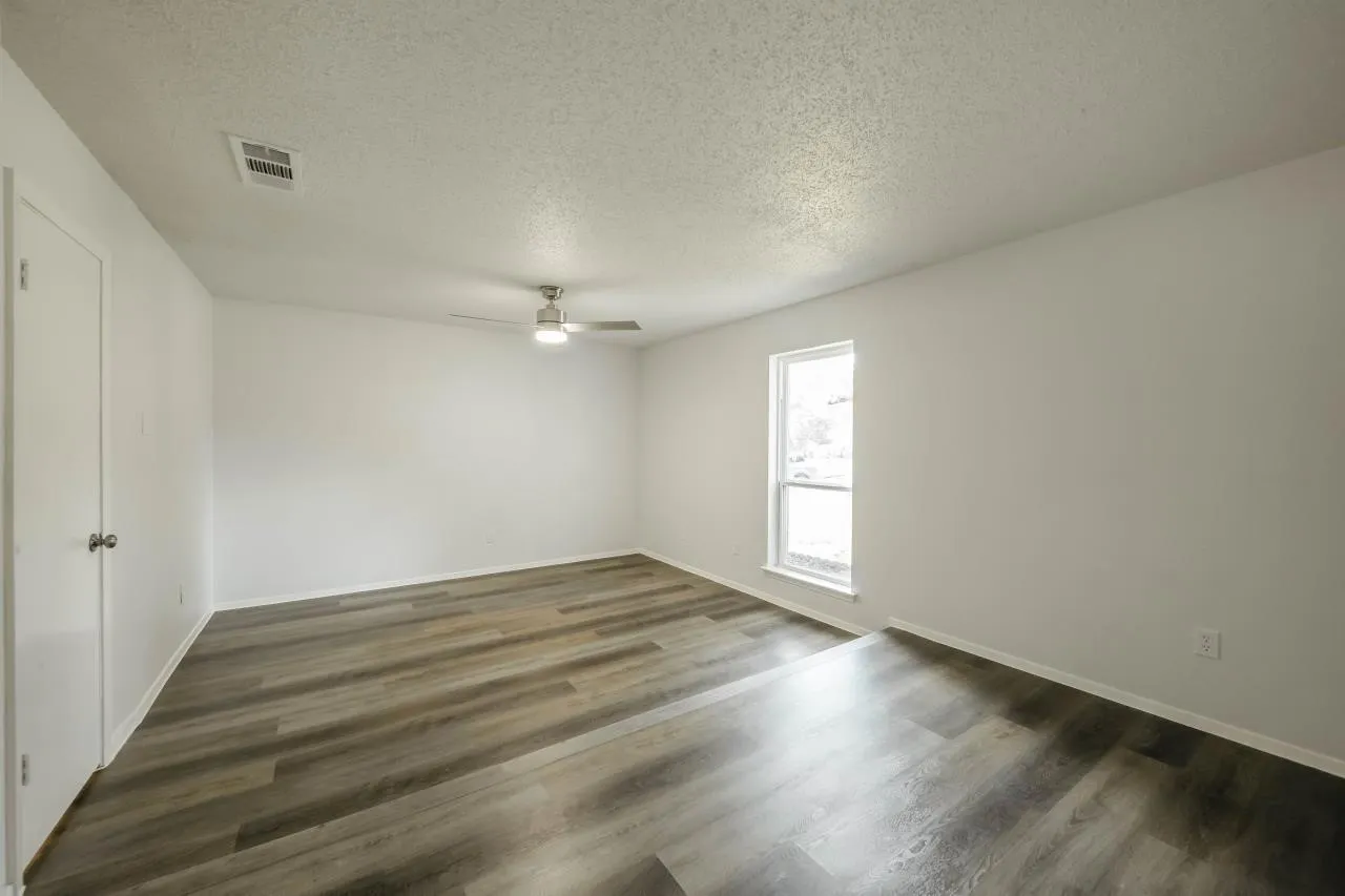 Neutral wall palette with wood-finish flooring, recessed lighting, and a brushed nickel ceiling fan
