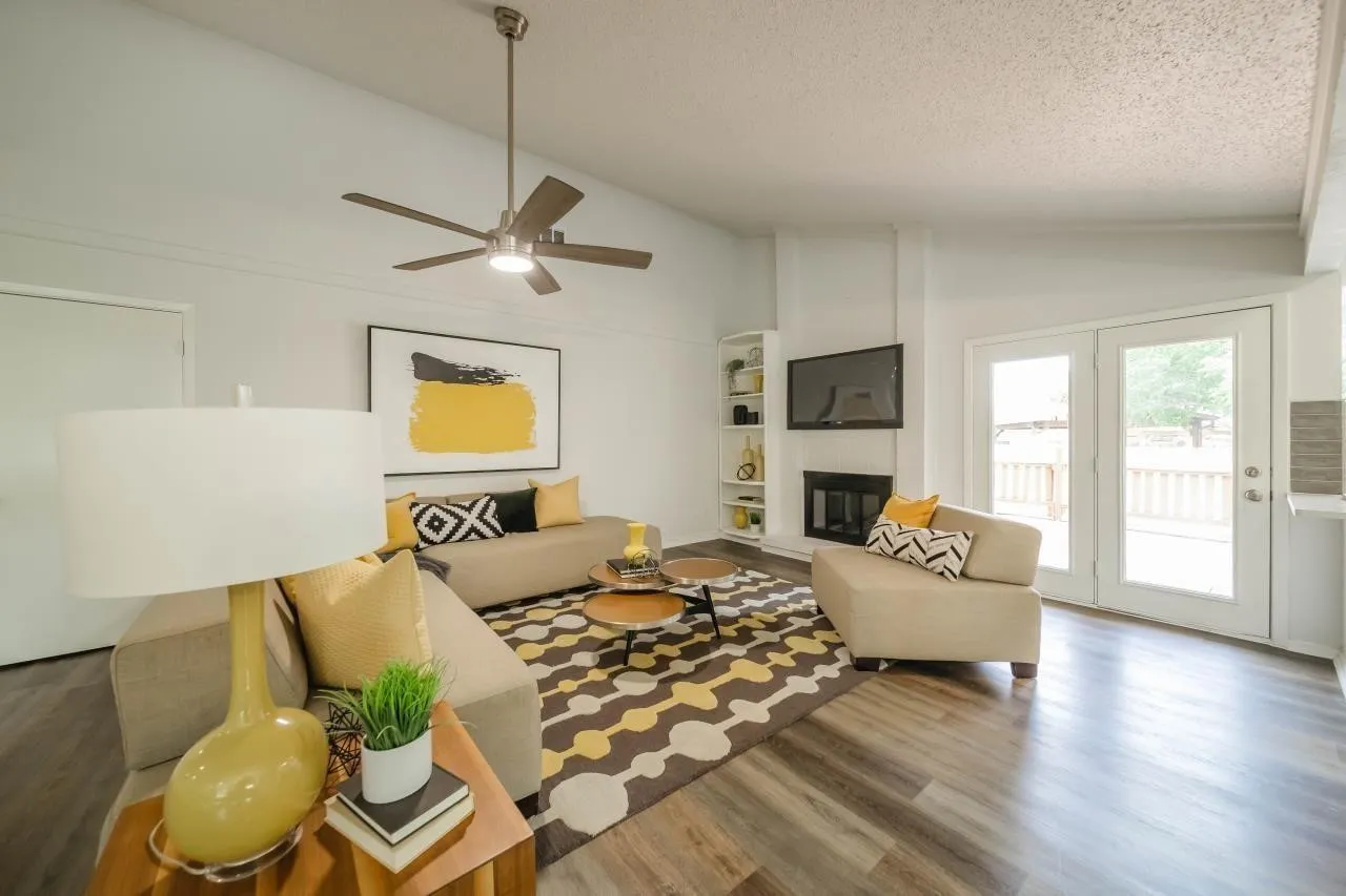 Vaulted ceilings, wood-finish flooring, built-in shelving, fireplace, and double French doors