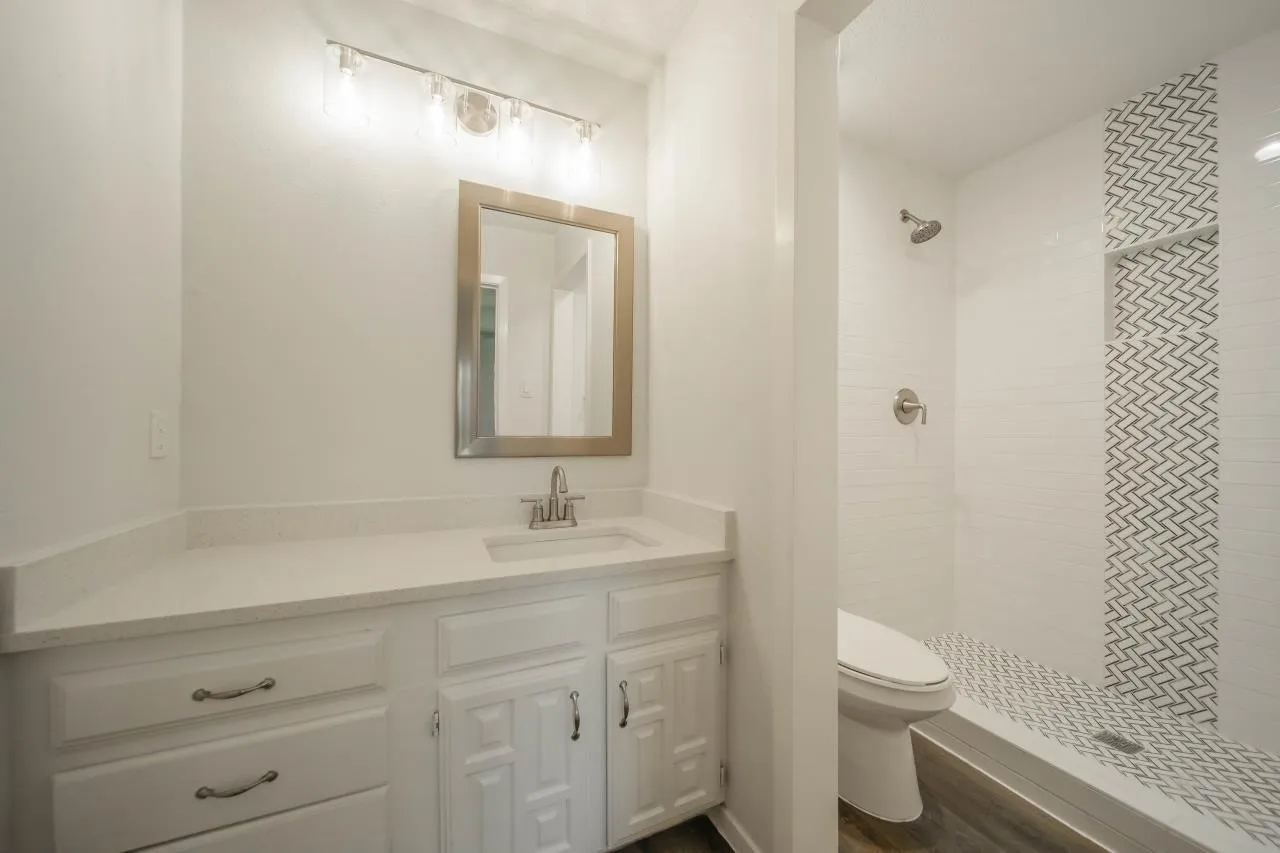 Bathroom vanity featuring white cabinetry, a light-toned countertop, and integrated rectangular sink