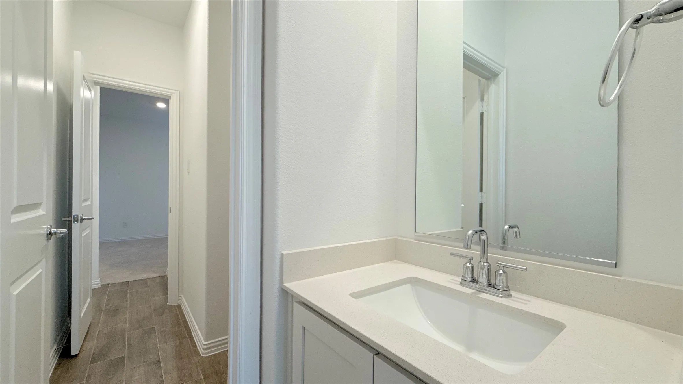 Vanity with an integrated rectangular sink, chrome-finish faucet, and a large mirror