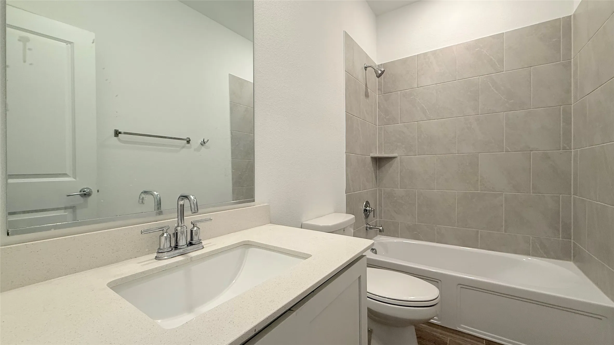Bathroom featuring a single vanity with an undermount sink, a chrome faucet, and a stone-finish countertop