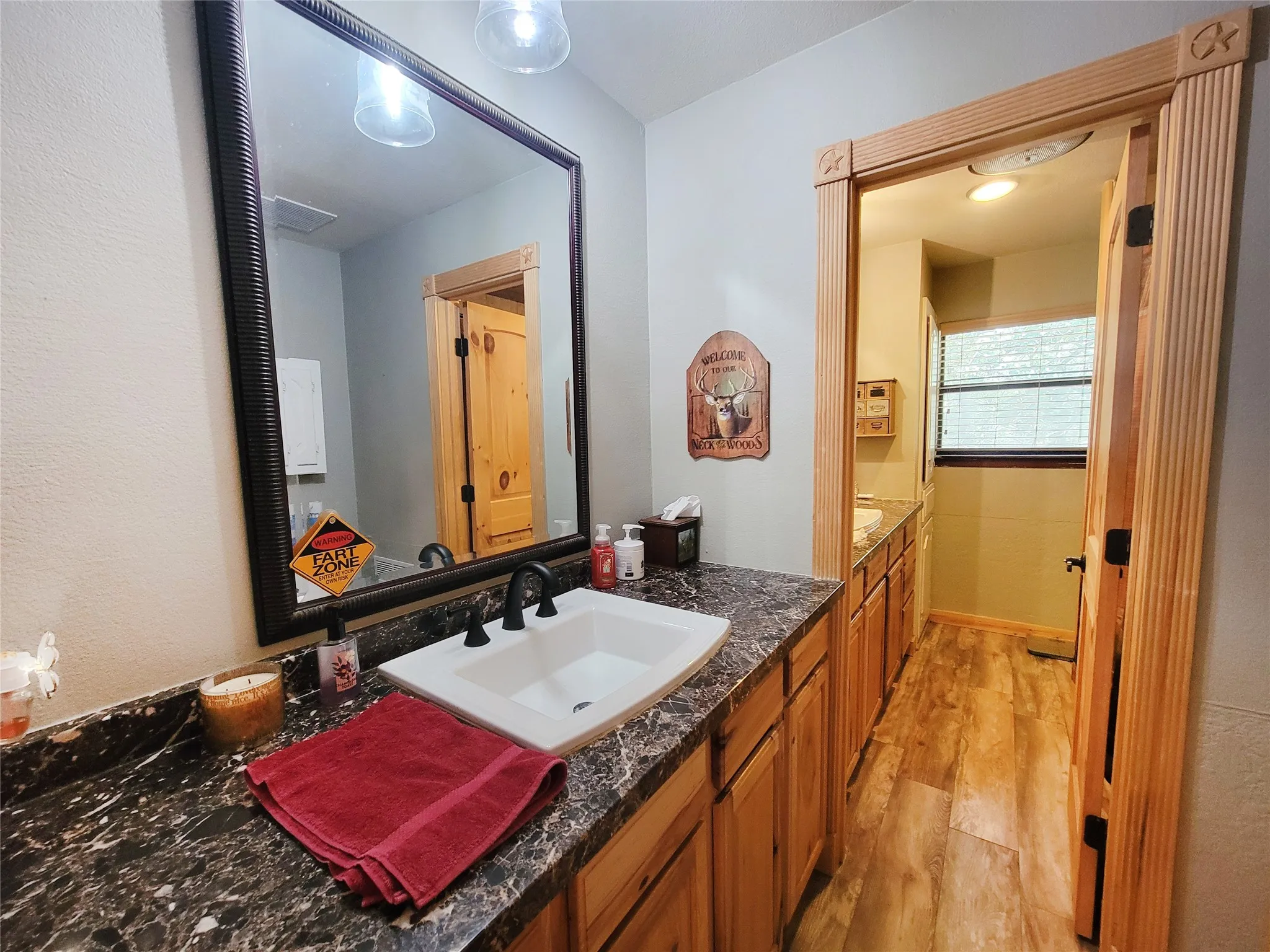Spacious vanity featuring a large framed mirror, dark countertop, and integrated sink with a matte black faucet