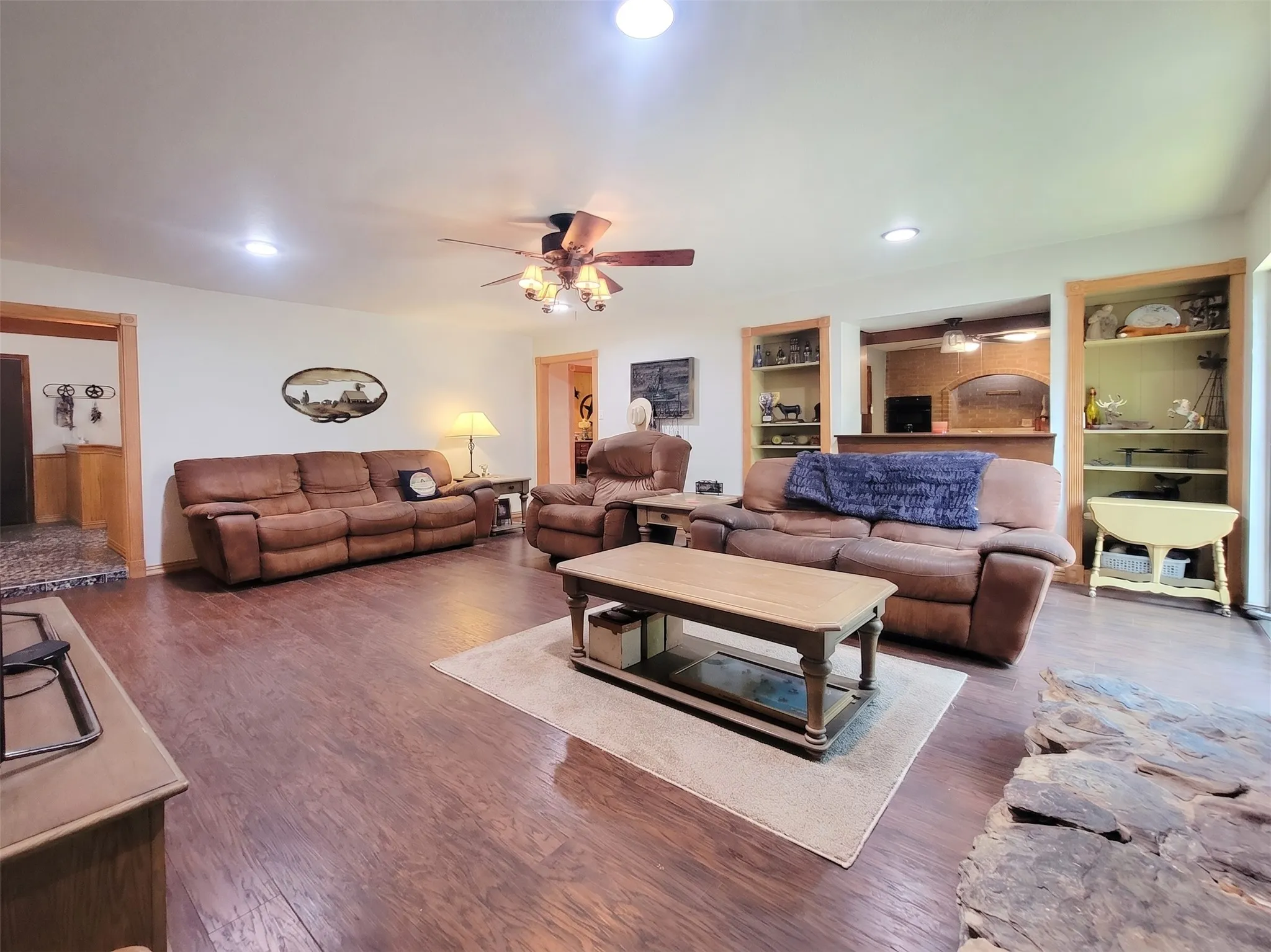 Spacious living area featuring wood-finish flooring, recessed lighting, and a ceiling fan