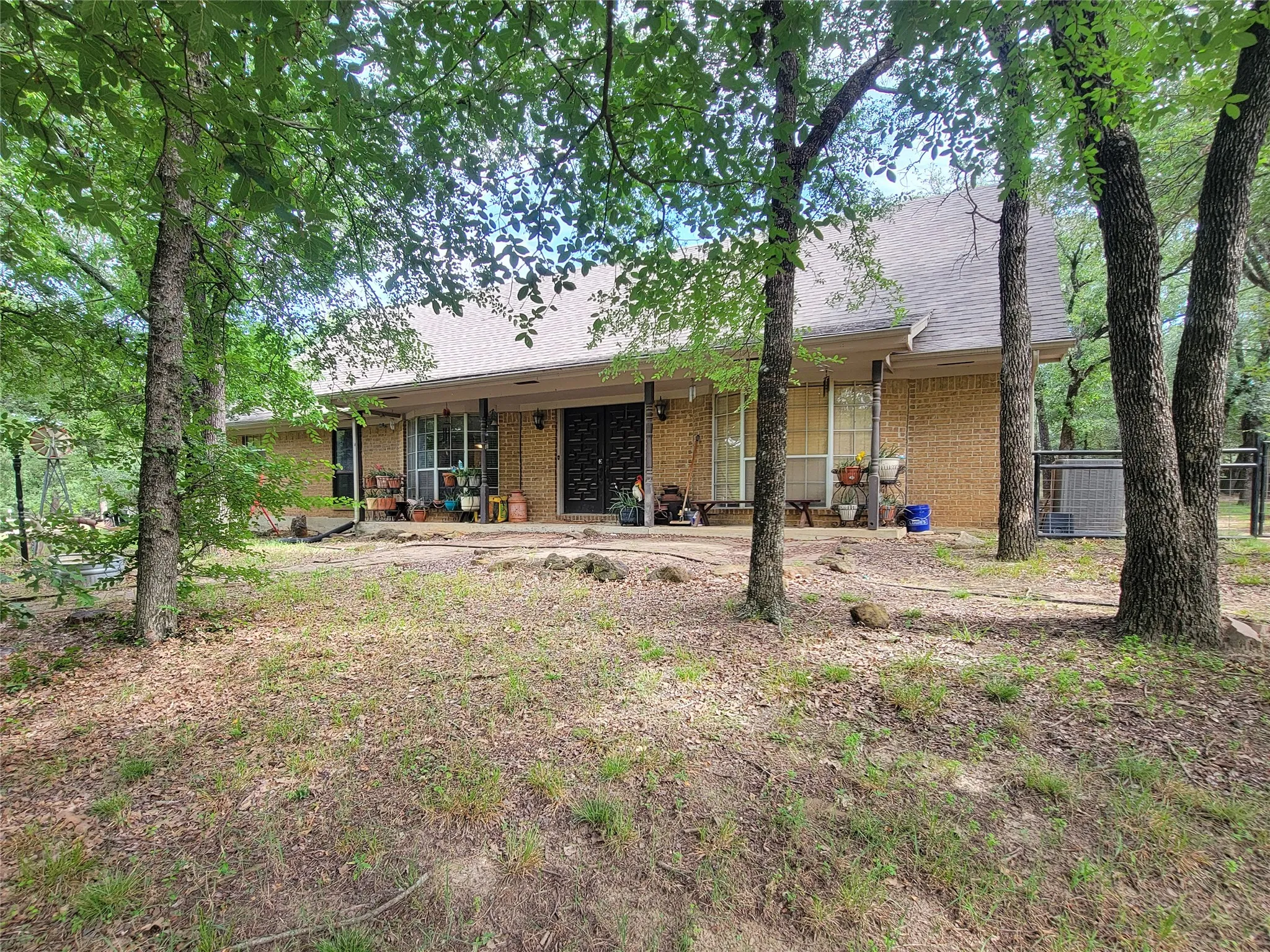 Brick exterior with a covered porch, multiple windows, and a dark entry door