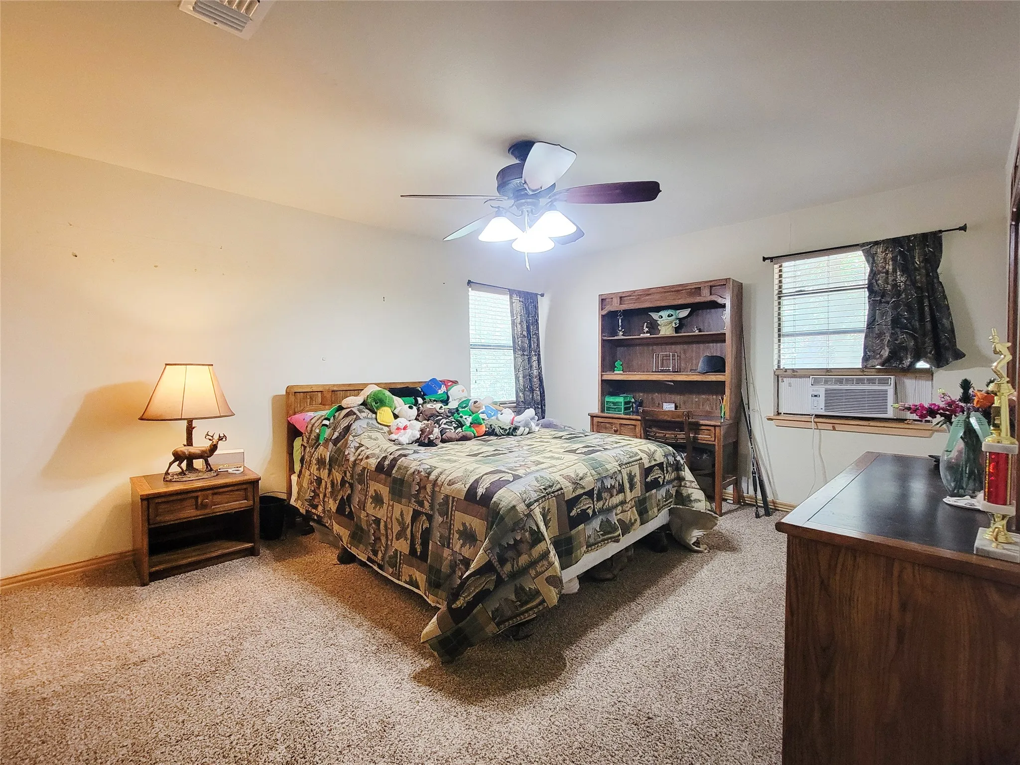 Carpeted flooring, ceiling fan with light fixture, and windows with blinds