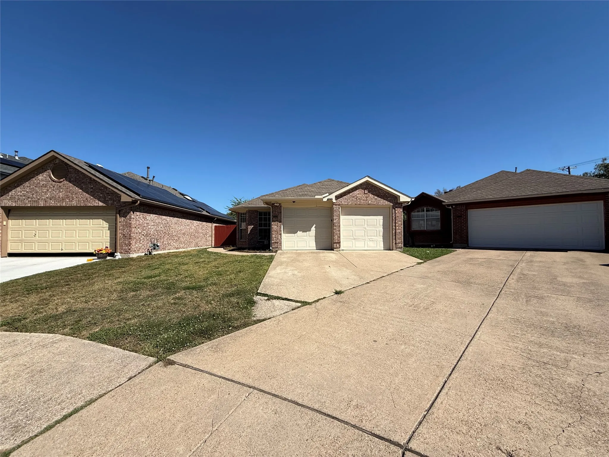 Single-story residence featuring a brick exterior, attached two-car garage, and concrete driveway