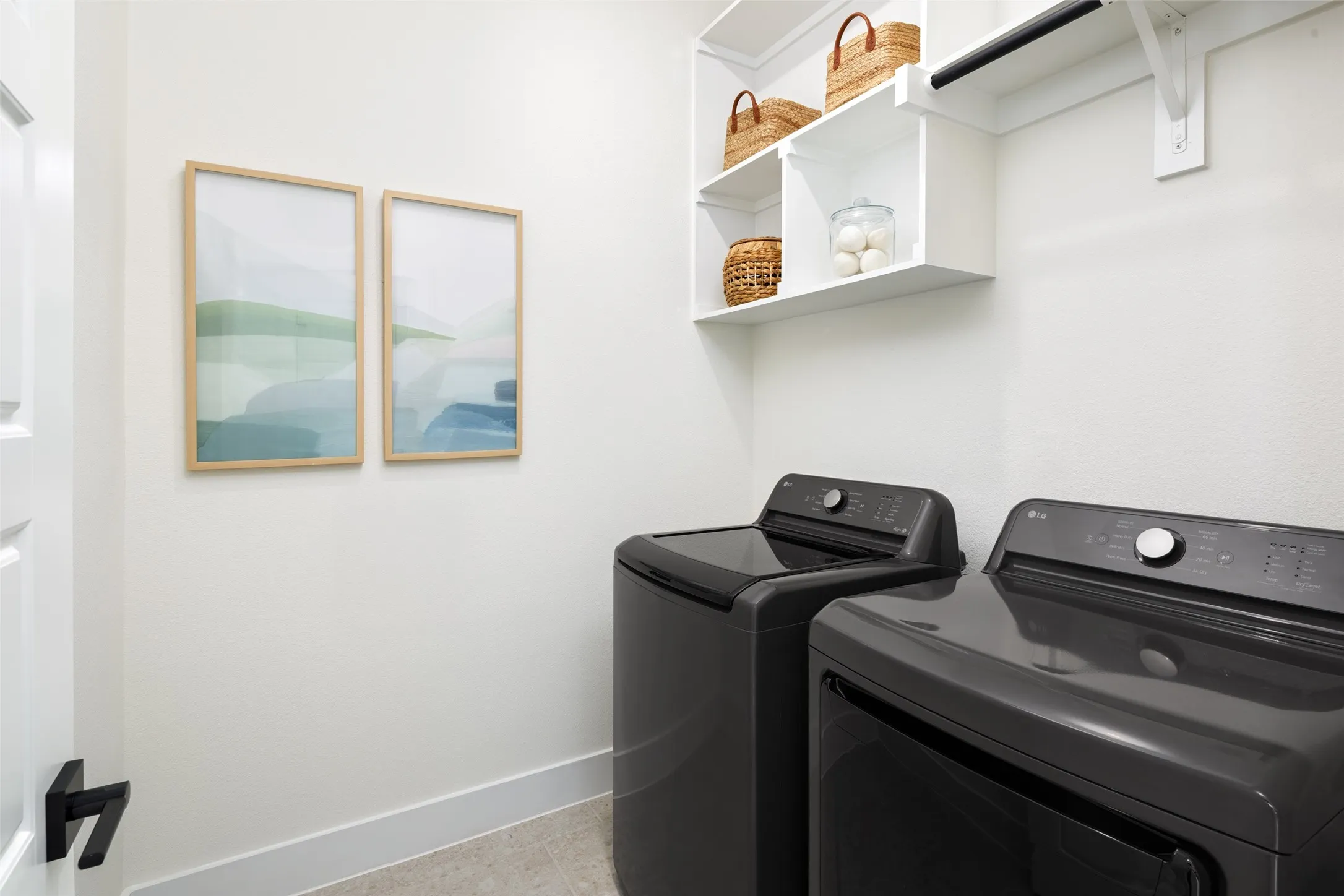 Laundry area featuring a top-load washer, front-load dryer, built-in shelving, and a hanging rod