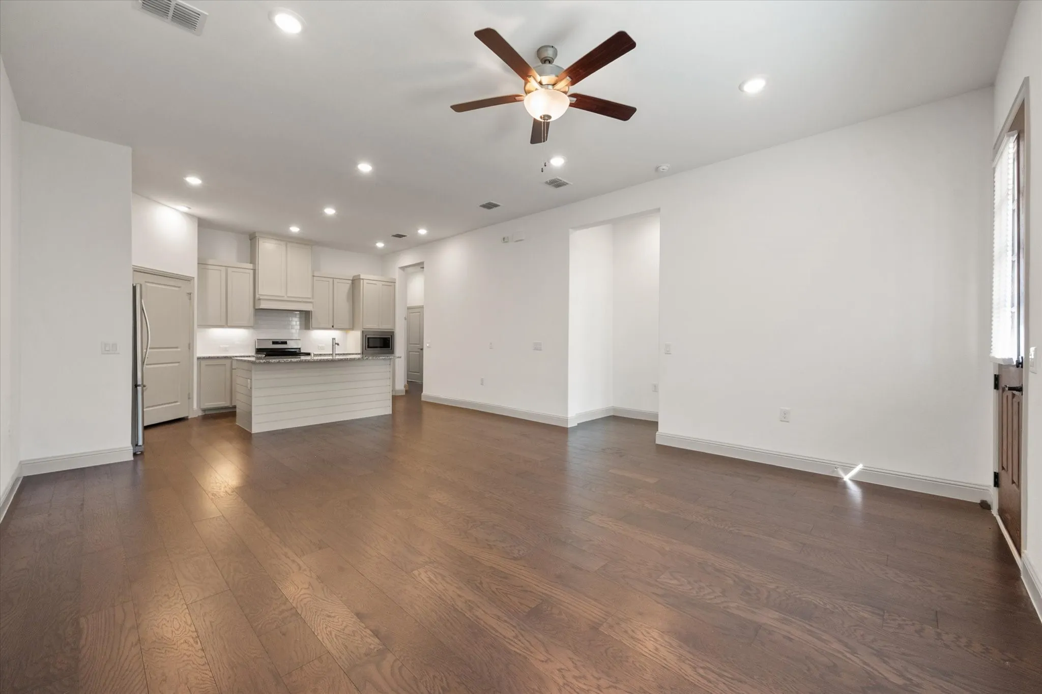 Wood-finish flooring throughout, recessed lighting, and a ceiling fan