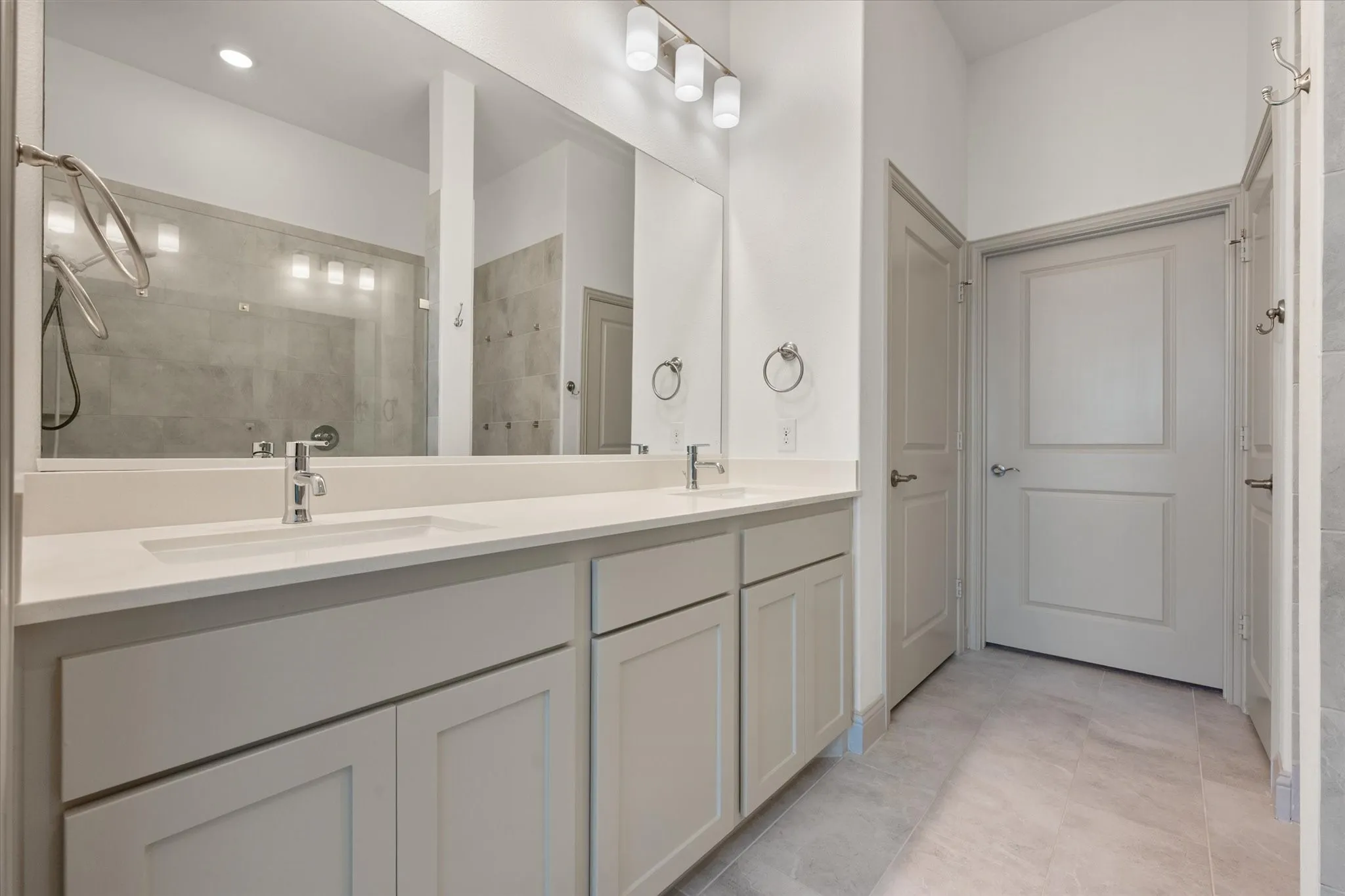 Dual vanity with undermount sinks, chrome fixtures, and light-toned cabinetry