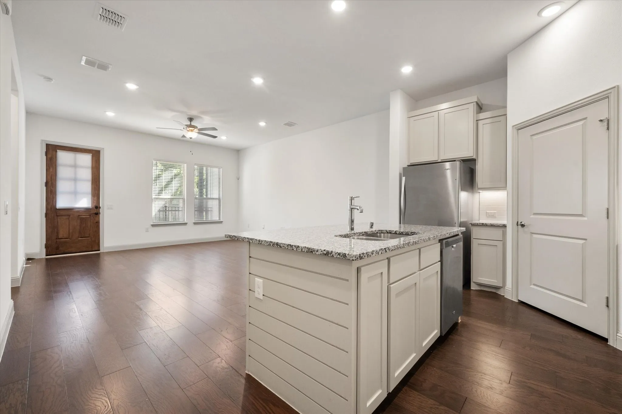 Wood-finish flooring throughout, recessed lighting, and a ceiling fan