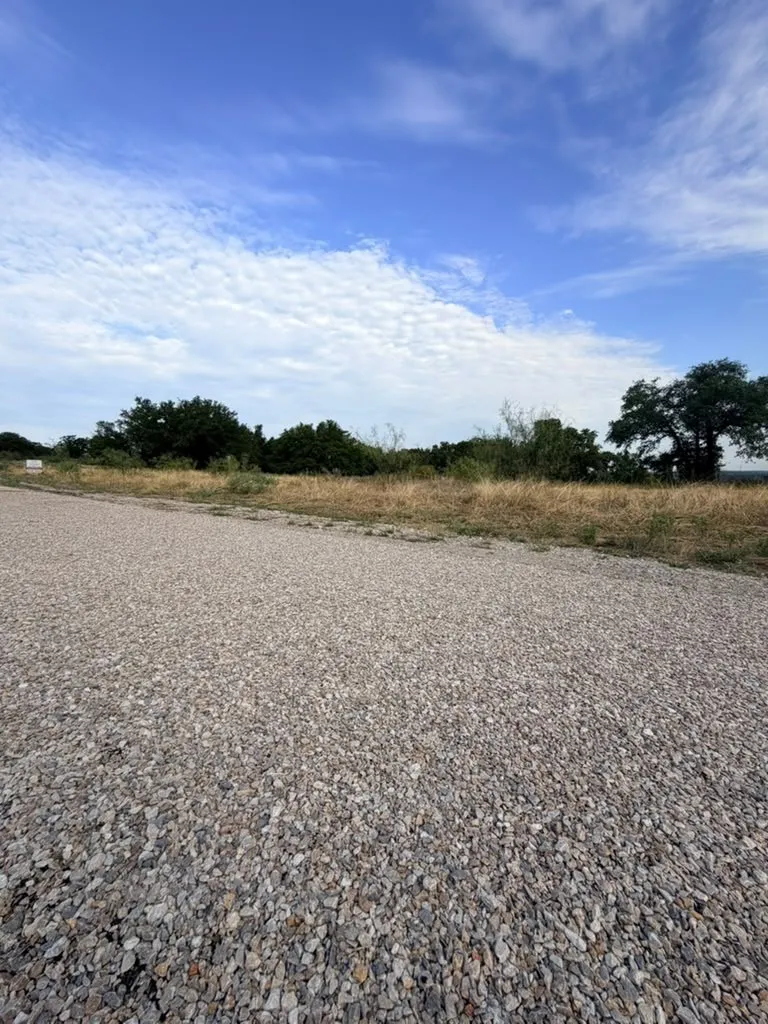 Expansive acreage featuring a gravel road, open meadow, and mature trees