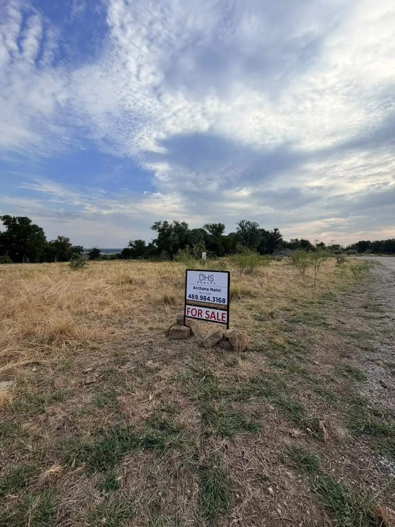Expansive unimproved land parcel featuring mature trees and native grasses