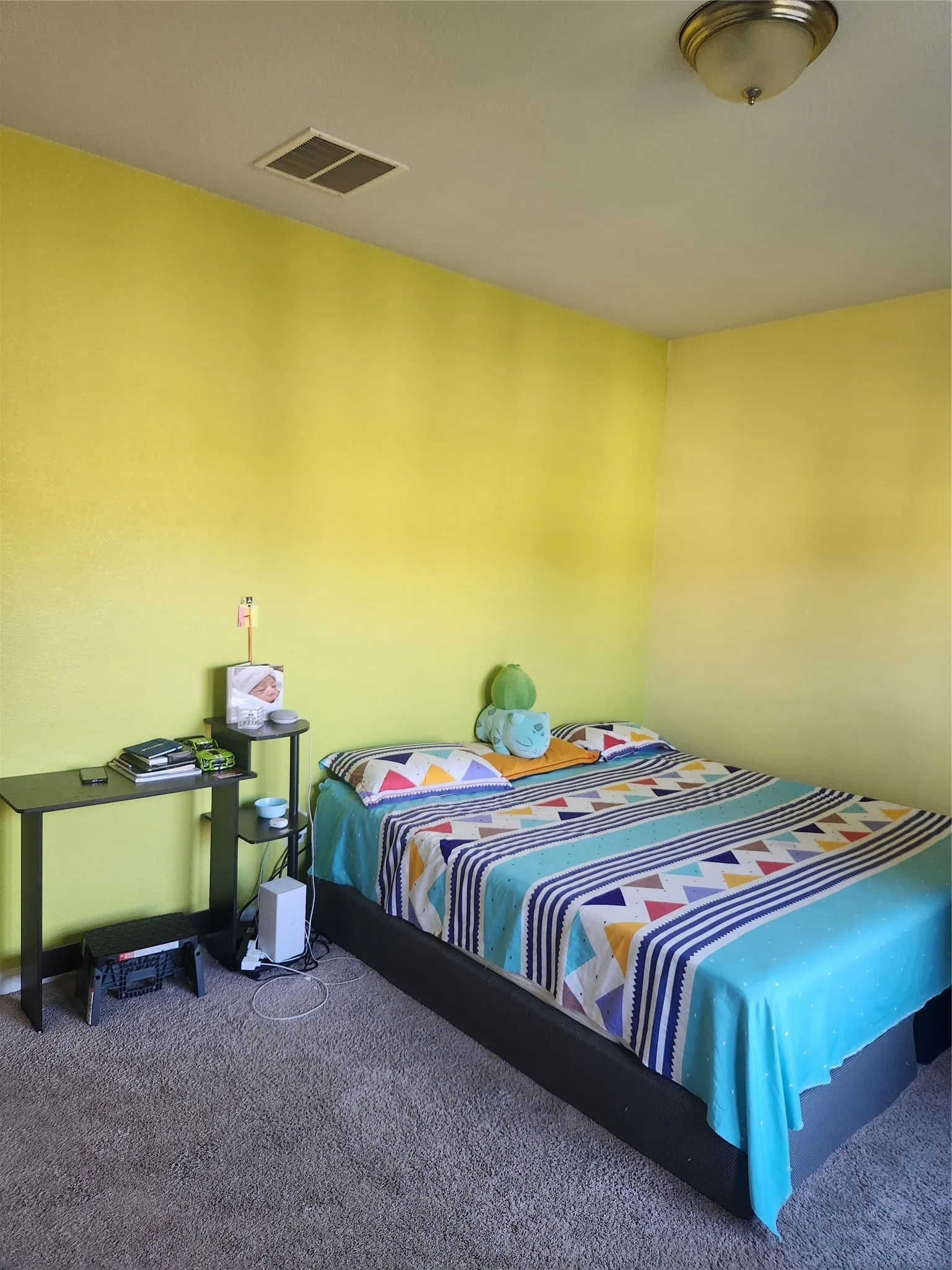 Carpeted flooring, contemporary light fixture, and vibrant wall color