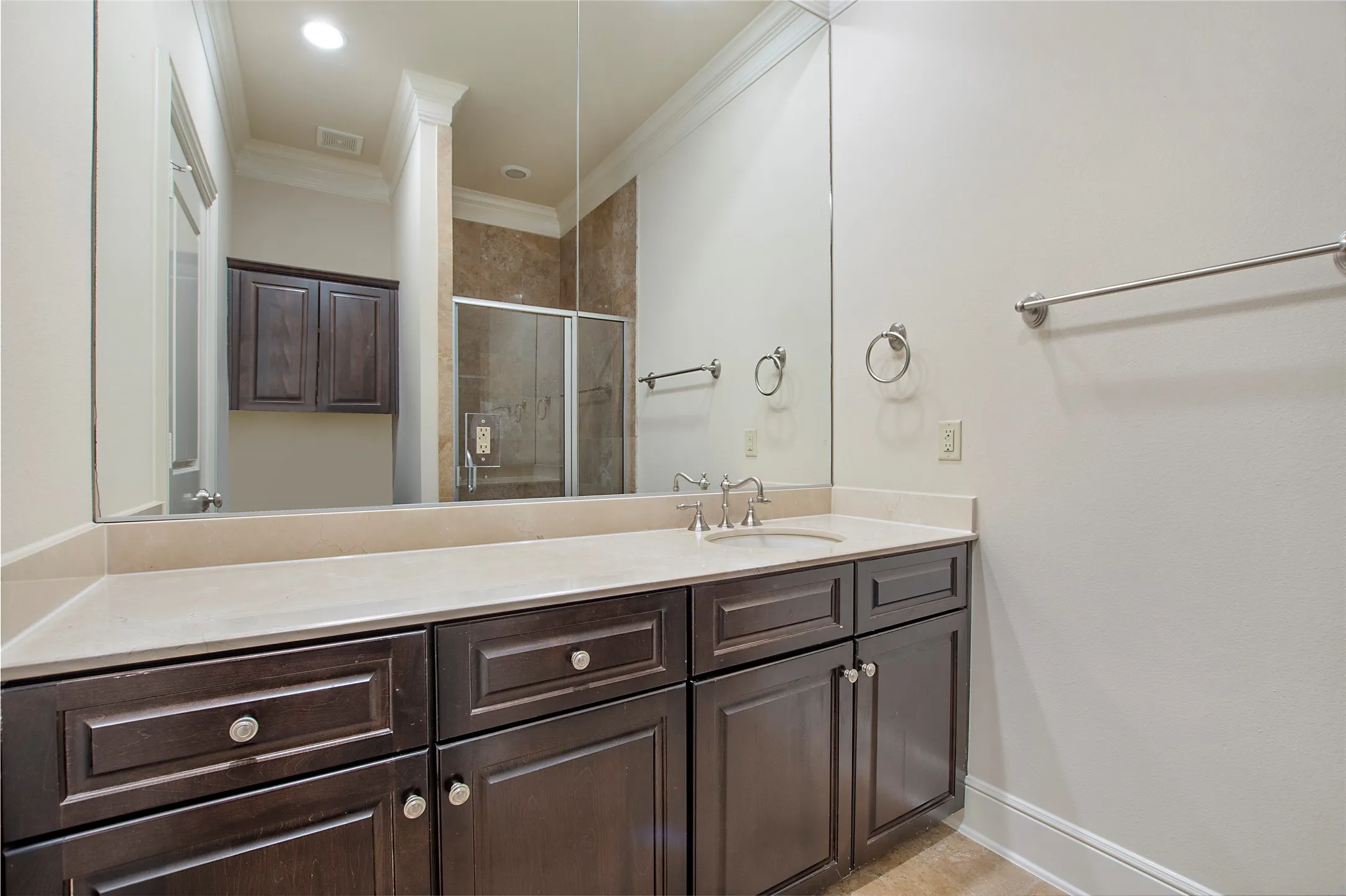 Bathroom featuring a shower with door, ornamental molding, and vanity