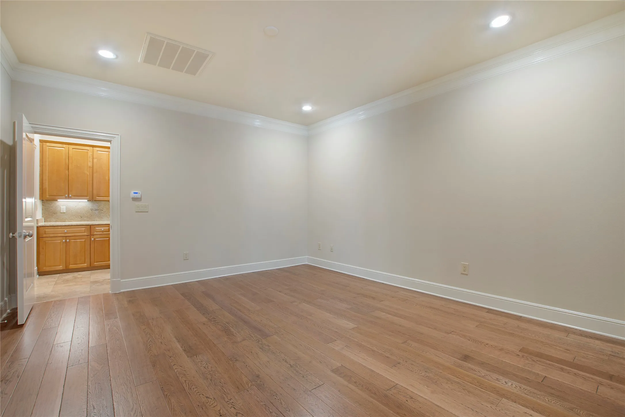 Empty room featuring light hardwood / wood-style floors and ornamental molding