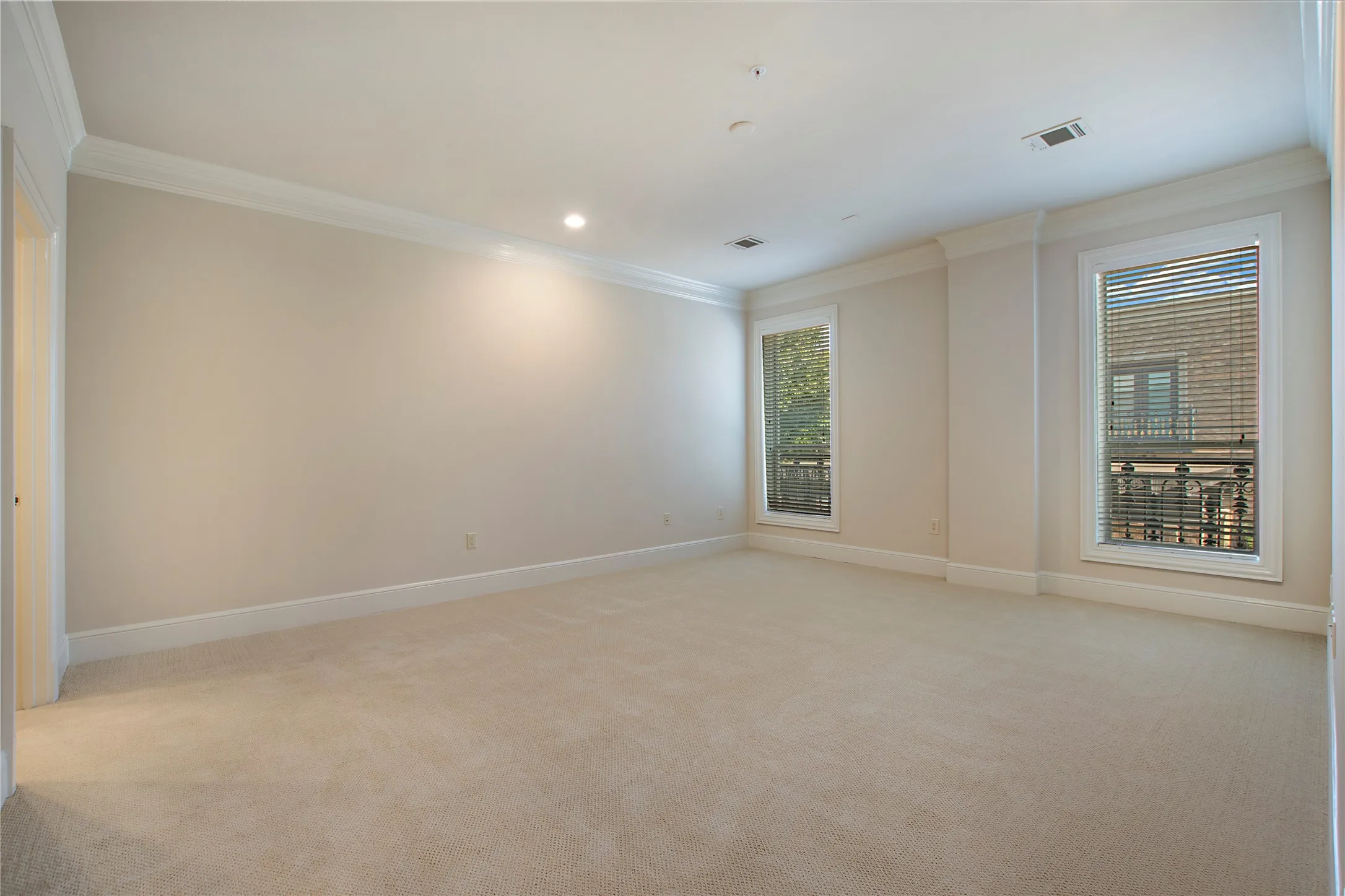 Unfurnished room with a wealth of natural light, crown molding, and light carpet