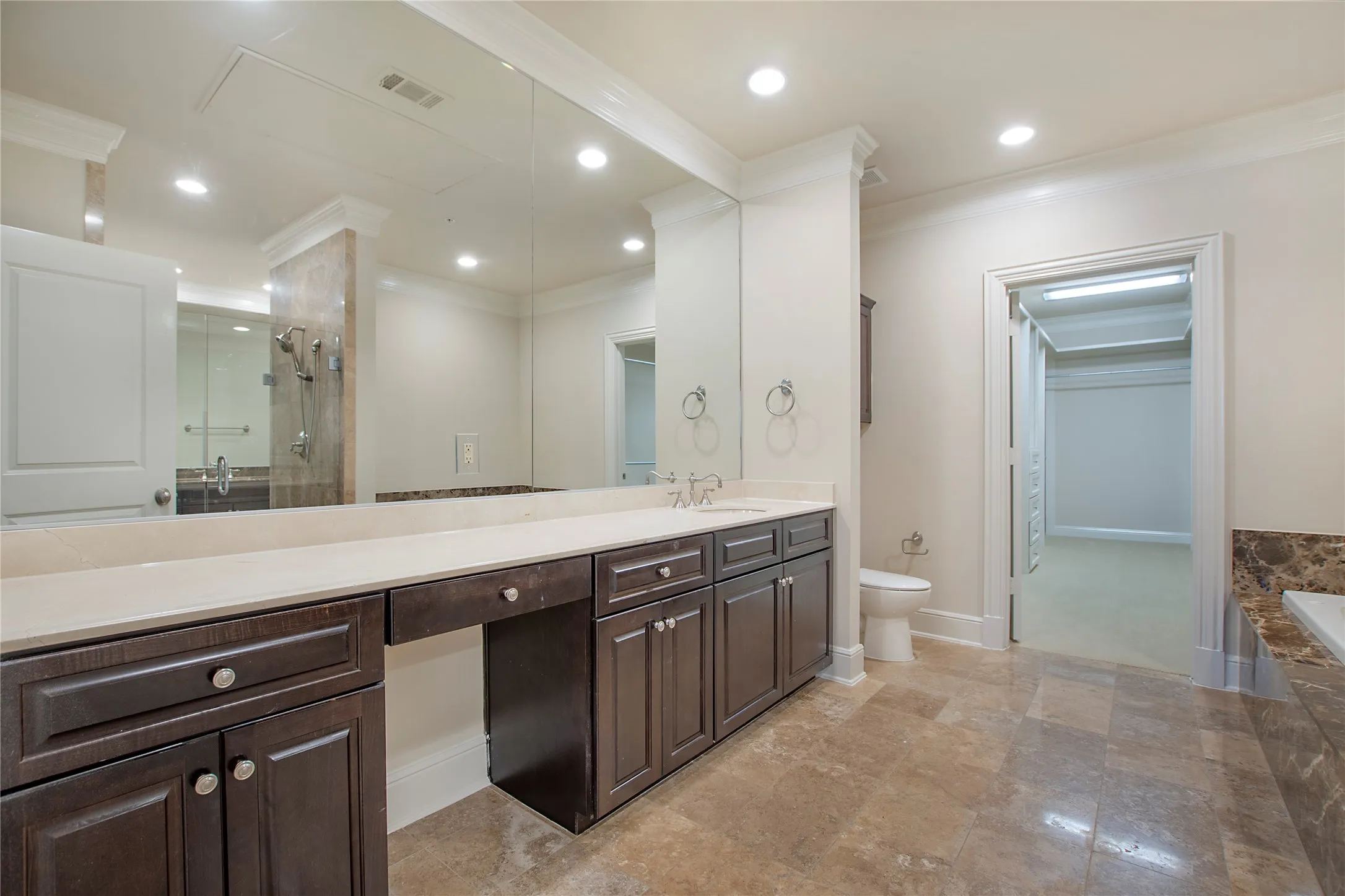 Full bathroom featuring vanity, toilet, crown molding, and plus walk in shower